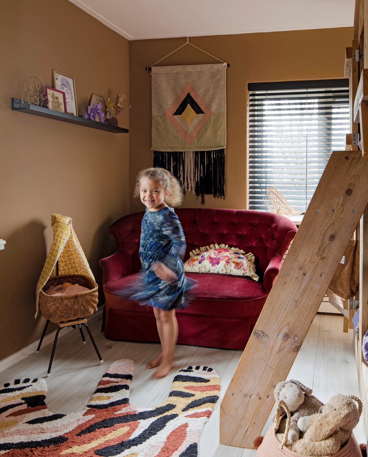 Velours bankje familiestuk, rotan poppenwieg vintage, wandkleed Karwei, vloerkleed Kwantum, kussen Ikea, raambekleding DIB. Muurverf Spiced Honey Flexa. Overig onbekend. vtwonen 12-2022 | fotografie Corine Hoge Bavel