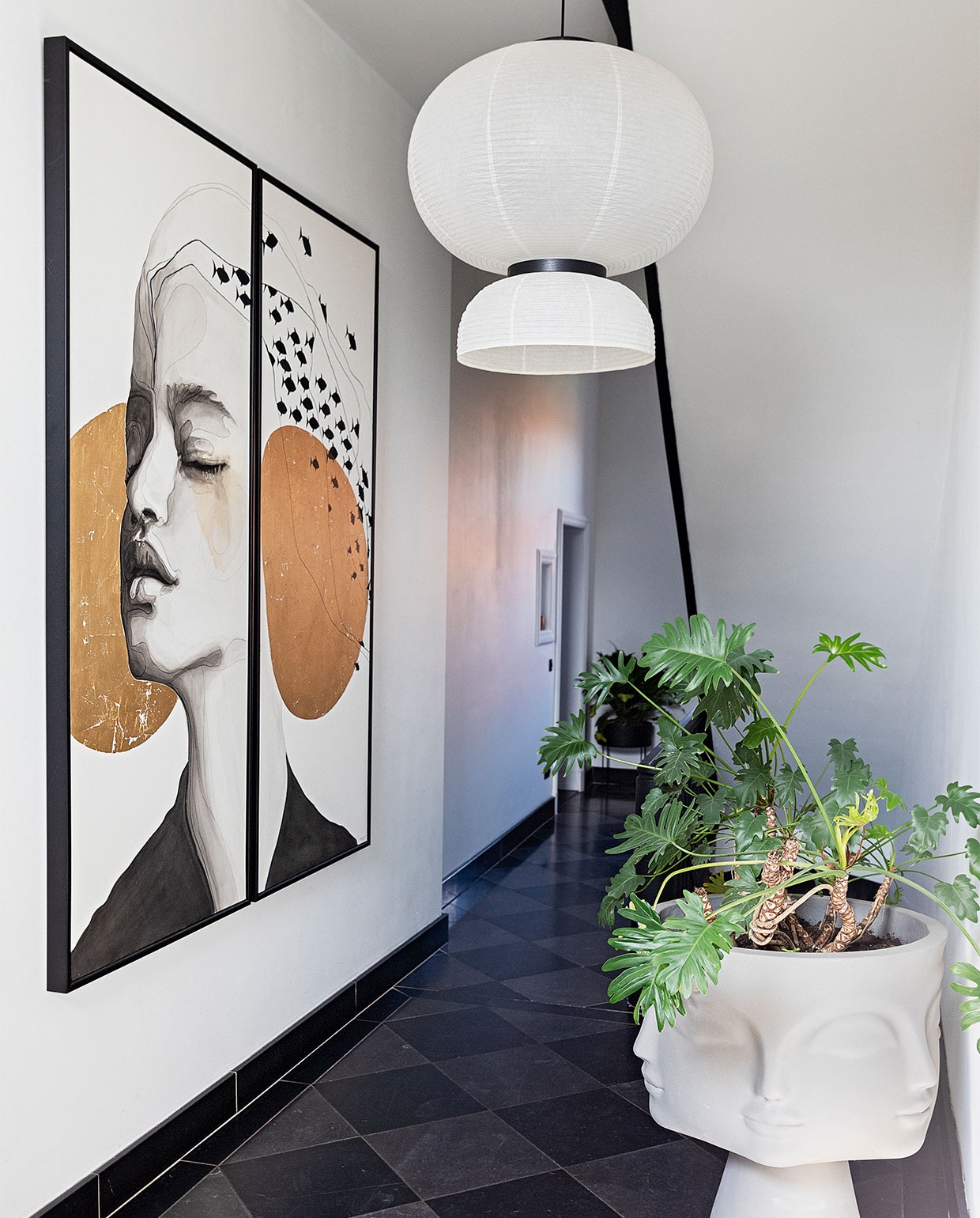 Witte muurverf RAL 9010.,  Plafondlamp Petit Friture via Interior Playground. Natuurstenen kerkvloer. Kleed Benuta. Marmeren tafel Papadatos via Decor Amsterdam. Witte vazen en kaars Albaster via Graanmarkt 13. Bloemen Van Esch Floral. Goudkleurige kandelaar en kandelaar rechts op kast Fritz Hansen via Loft 76. Bouclé stoel en kandelaar Ferm Living. Kussen Leclaireur. Bijzettafel Casa Gitane. Daarop: lamp &Tradition. Kristal Earth Mineralen. Kunstwerk stolp Neeltje Geurtsen. Vaas Menu. Tak Joy Flowers. Aan de muur kunstwerk Atelier de Rijk. Trolley BePureHome. Daarop: kandelaars Anissa Kermiche. Geurstokjes Baobab. Schilderij Cate Adriana. Plantenpot &Tradition. Behang Selva van Arte. JA | vtwonen 11-2021 | styling Ilona Jongepier  | fotografie Dana van Leeuwen