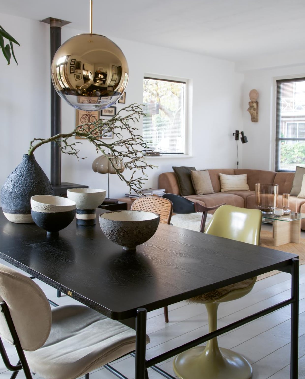 Oude Thonet-stoeltjes Marktplaats. Zwarte tafel Hübsch. Groene stoel met tulpvoet van Casa Gitane. Vazen en schalen handgemaakt door Liesbeth Spreeuwenberg. Designlamp Tom Dixon. Bank en plaid HKliving.