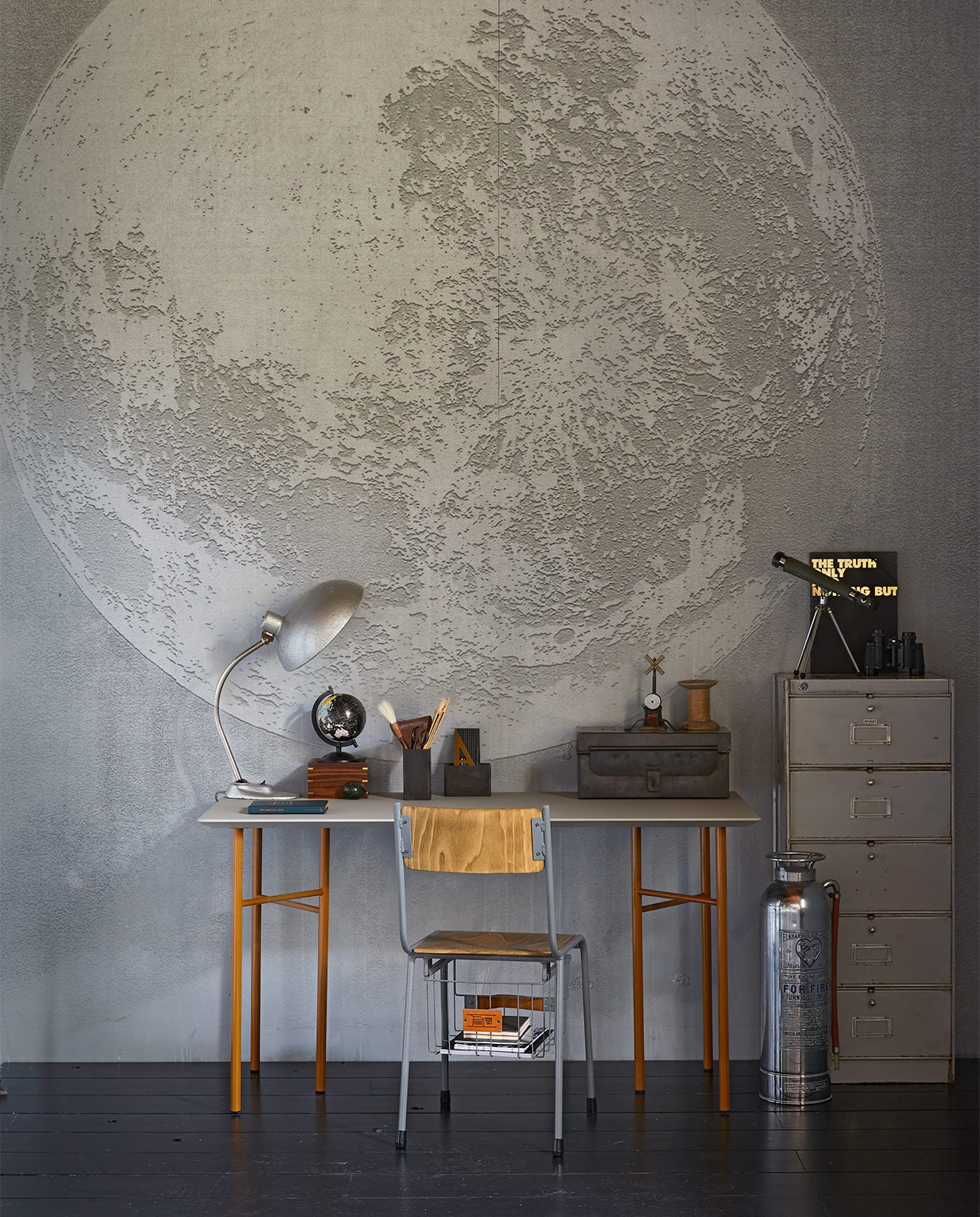 Behang Luna Plena WDLU1702, per m² € 110,- (Wall&amp;decò). Gereedschapskist , € 119,-, brandblusser € 175,-, bureaulamp € 165,-, pennenbak hoog € 14,95, pennenbak laag € 14,95, kleppenkast, 50x40x100 cm (bxdxh) € 195,- (Brût Amsterdam). Storage stoel, hoogte 45 cm € 169,- (www.storage-stool.com). Vintage sterrenkijker € 65,- (All the Luck in the World). Tafelblad Mingle, 135×65 cm € 599,-, okergeel tafelonderstel Mingle van Ferm Living, hoogte 74 cm € 199,- (Kolk en Kolk). Zwarte map met gouden tekst € 10,95 (&amp;klevering). Klosje € 5,-, leren etui met schaar € 15,- (Combitex). Gouden geodriehoek € 37,50 (My Deer Art Shop). Houten doosje met sterrenkijker € 54,95 (De Weldaad). Wereldbol en verrekijker privébezit. JA | vtwonen 10-2017 | styling Cleo Scheulderman | fotografie Jeroen van der Spek