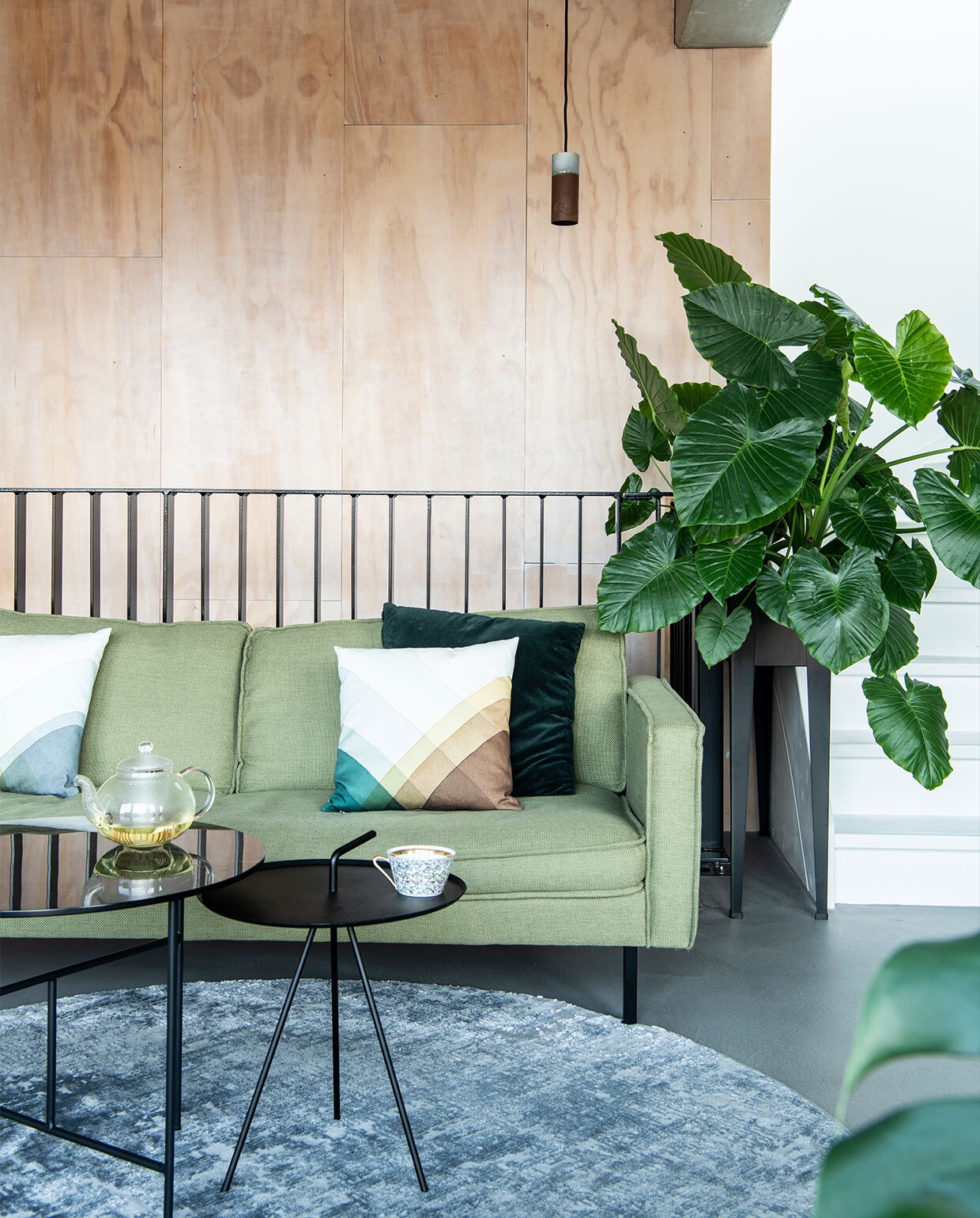 Bank Loods 5 Design. Herringbone kussens van Vitra via Groen + Akker. Groen kussen en plantenstandaard Intratuin. Vloerkleed Gusta. Hoge bijzettafel Loods 5. Lage bijzettafel Woood. Vloerlamp Zuiver. Hanglamp Roest van Van Joost voor Graypants. Theepot Bredemeijer. Theekop vintage. Plantenstandaard Intratuin. Wandbekleding underlayment platen. vtwonen 11-2021 | productie Insidehomepage | styling en tekst Inge van Lieshout | fotografie Louis Lemaire | tekstbewerking Jack Meijers