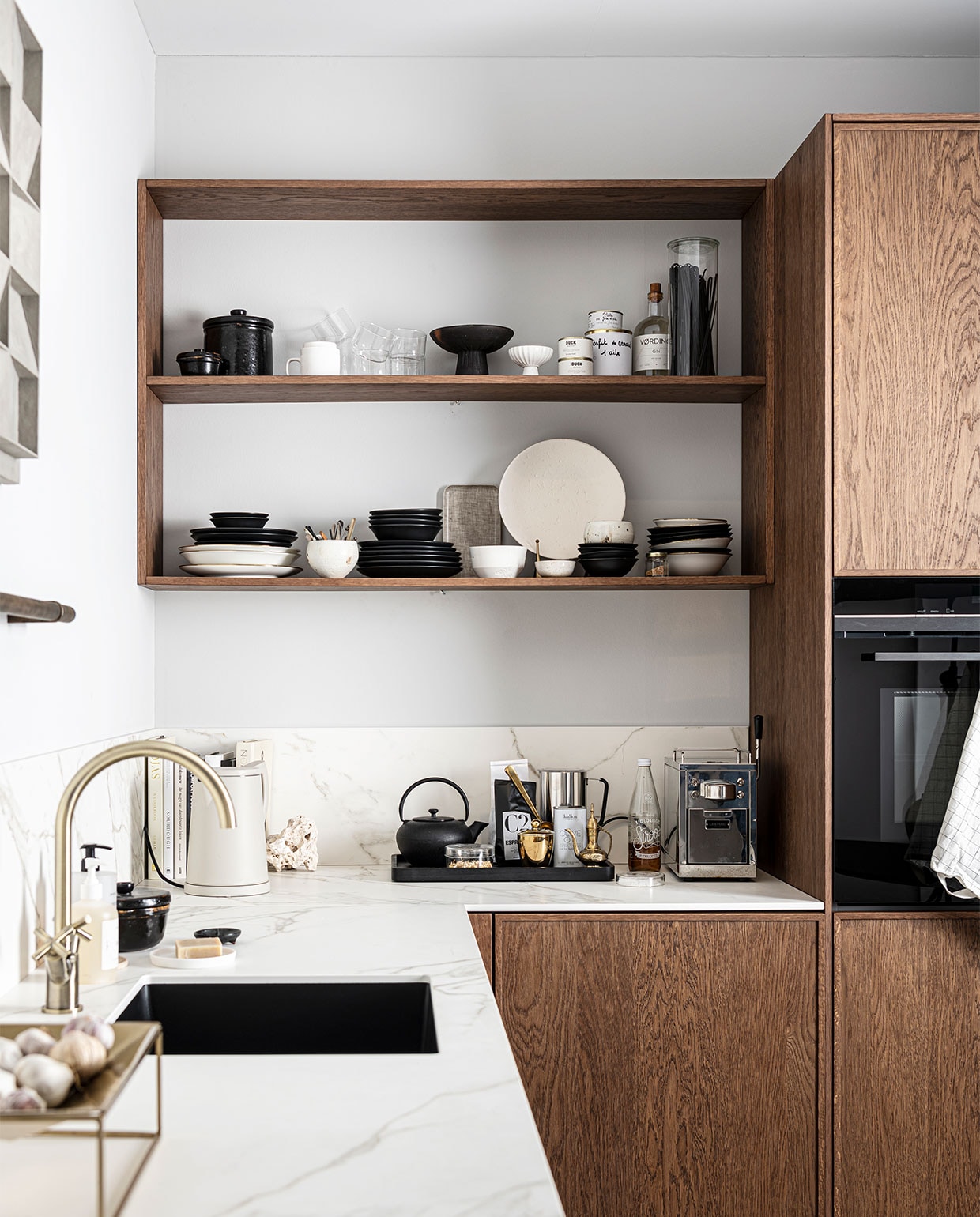 Keuken Dark Oak zoals getoond, exclusief accessoires € 19.950,- | M.m.v zarahome.com (opbergpot en bord met bordenstandaard), casagitane.com (schaal op poot), vtwonen.nl (glazen en servies van vtwonen), sjostrandcoffee.nl (koffiezetapparaat en melkopschuimer), vtwonen.nl (dienblad en theepot van Serax, waterkoker Sowden van Hay), thefinestore.com (dienblad). Overig privébezit. vtwonen 12-2021 | productie Tanja Saarberg | styling Kim van Rossenberg | fotografie Sjoerd Eickmans