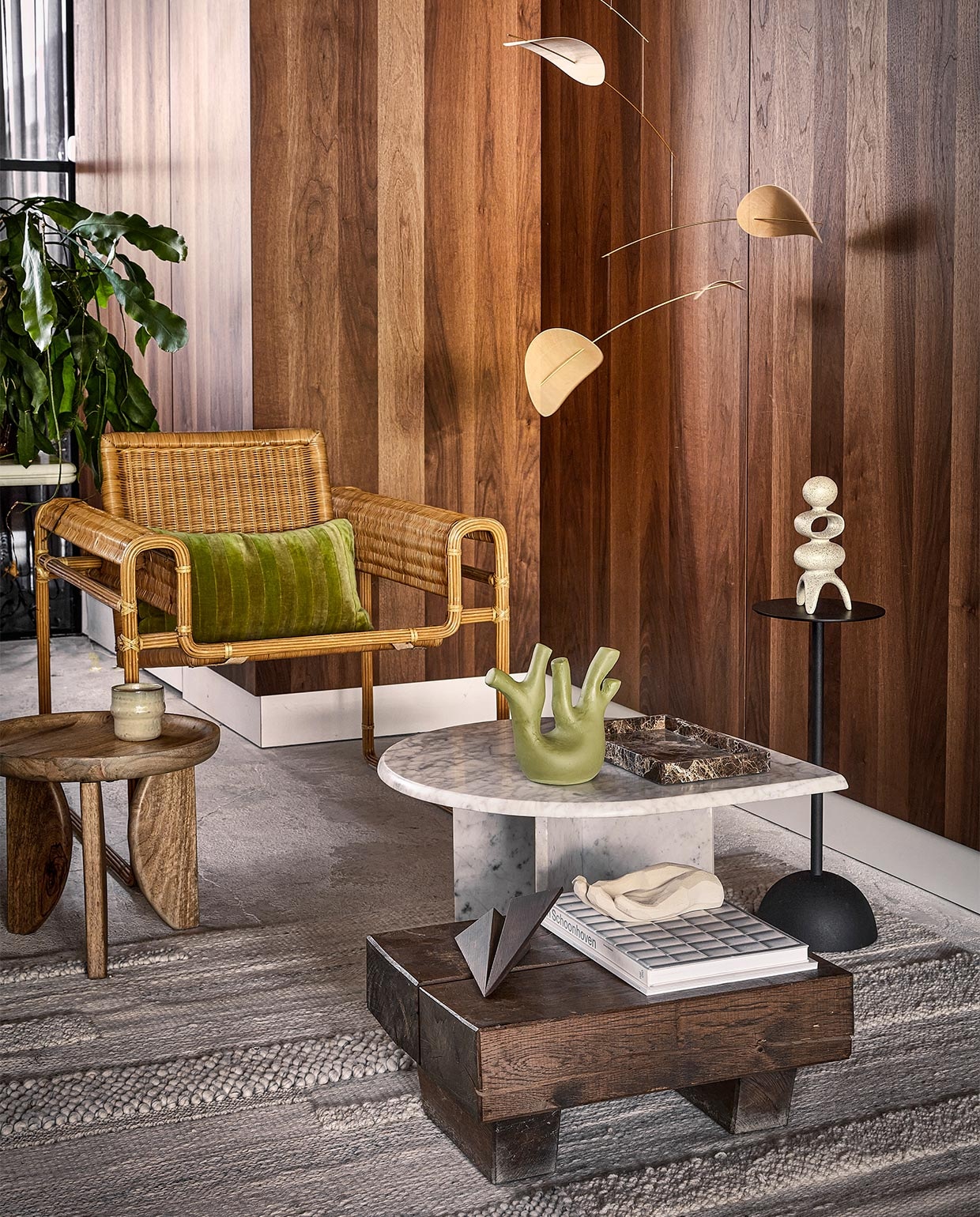 Muurpanelen met walnoothoutfineer prijs op aanvraag (cocoon-living.nl). Vintage wickerstoel in Wassily Chair-stijl € 2950,-, vintage salontafel van Carrara-marmer € 875,-, marmeren dienblad € 98,-, lage tafel van antieke spoorbielzen, set van 2 € 550,- (cocooncollectables.nl). Mangohouten bijzettafel High Heels, set van 2 € 249,- (vtwonen.nl). Mok Nara, set van 4 € 26,95 (loods5.nl). Groene ecomix sculptuur Tree € 39,95, matzwarte, aluminium bijzettafel € 59,95, beige ecomix sculptuur Space € 39,95 (urbannatureculture.com). Betonzandstenen hand Bless van Cooee X Kristiina € 72,50, eikenhouten vliegtuig Maverick Plane van Boyhood € 59,50, houten mobiel Drifting Clouds van Flensted, 70×100 cm € 135,- (deensedingen.nl). Vloerkleed Brönden, 170×240 cm € 349,- (ikea.nl). Boek privébezit. vtwonen 10-2022 | styling Kim Timmerman | fotografie Peggy Janssen