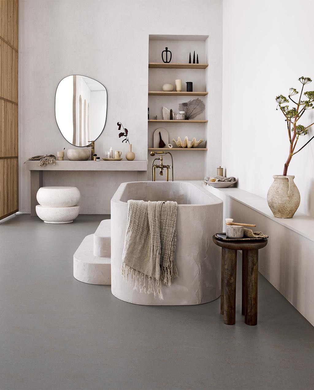 Marmoleum vloer Lava vtwonen 11, per m² € 48,- (ex installatie) M.m.v.: Nordal.eu (bijzettafel, linnen handdoeken, marmeren potten, xl schelp, doos suéde), Lanena-home.com (kruk van microcement), Zarahome.com (spiegel, schaal en grote kan), Bungalow.dk (kannetje en ovalen schaal), Byjoa.nl (zwarte kan, vaas crème op plank, bol vaas). Overig is privébezit vtwonen 08-2022 | styling Cleo Scheulderman | fotografie Alexander van Berge | productie Tanja Saarberg