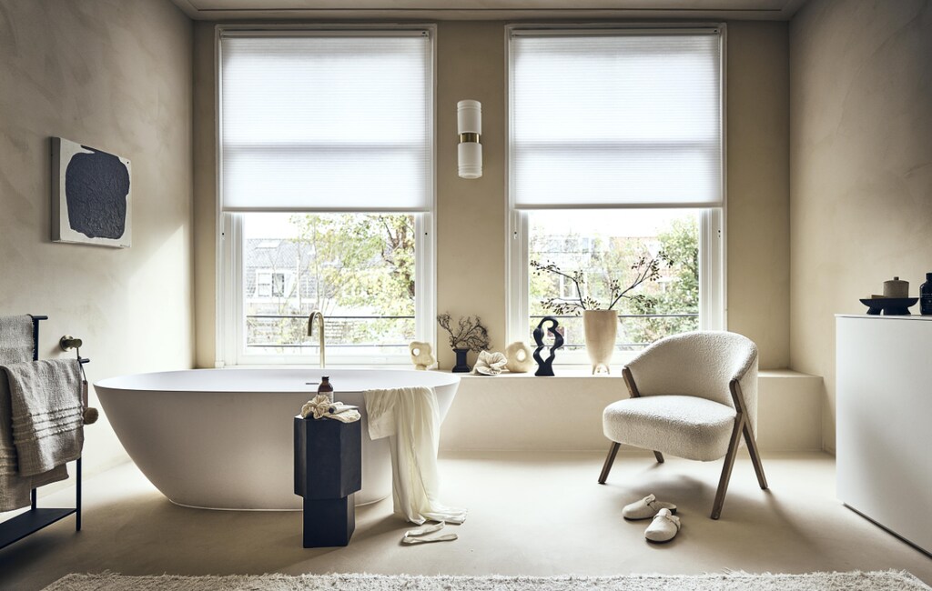 Witte stoel met houten poten en badstof bekleding € 299,-, badmat op rek € 19,99, handcrème € 15,99, vloerkleed € 219,-, sloffen € 25,99, beige bakje met deksel € 17,99, ochtendjas € 69,99, scrubhandschoen op zwart kastje prijs op aanvraag (zarahome.com). Zwart rek van Ferm Living € 189,- (vtwonen.nl). Beige plaid € 99,-, vaasje met rond gat links € 54,95, beige vaas in het midden € 57,95, zwarte siervorm € 79,95, grote beige vaas € 89,95, borstel €15,95 (eijerkamp.nl). Kunstwerk aan wand, prijs op aanvraag (@ansdekruyf). Papieren kunstwerk € 150,- (elsavisser.com). Zeep in fles € 18,-, losse zeep € 22,-, zeepfles op zwarte kruk, prijs op aanvraag (sukha.nl).  Zwarte natuurvorm € 35,- (taxidermy.nl). Zwarte schaal op drie poten € 19,99 (hm.com). Zwarte kruk € 249,- (aedamanthony.nl). Muurverf onbekend. Overig privébezit. vtwonen 1-2023 | styling liza wassenaar | fotografie sjoerd eickmans