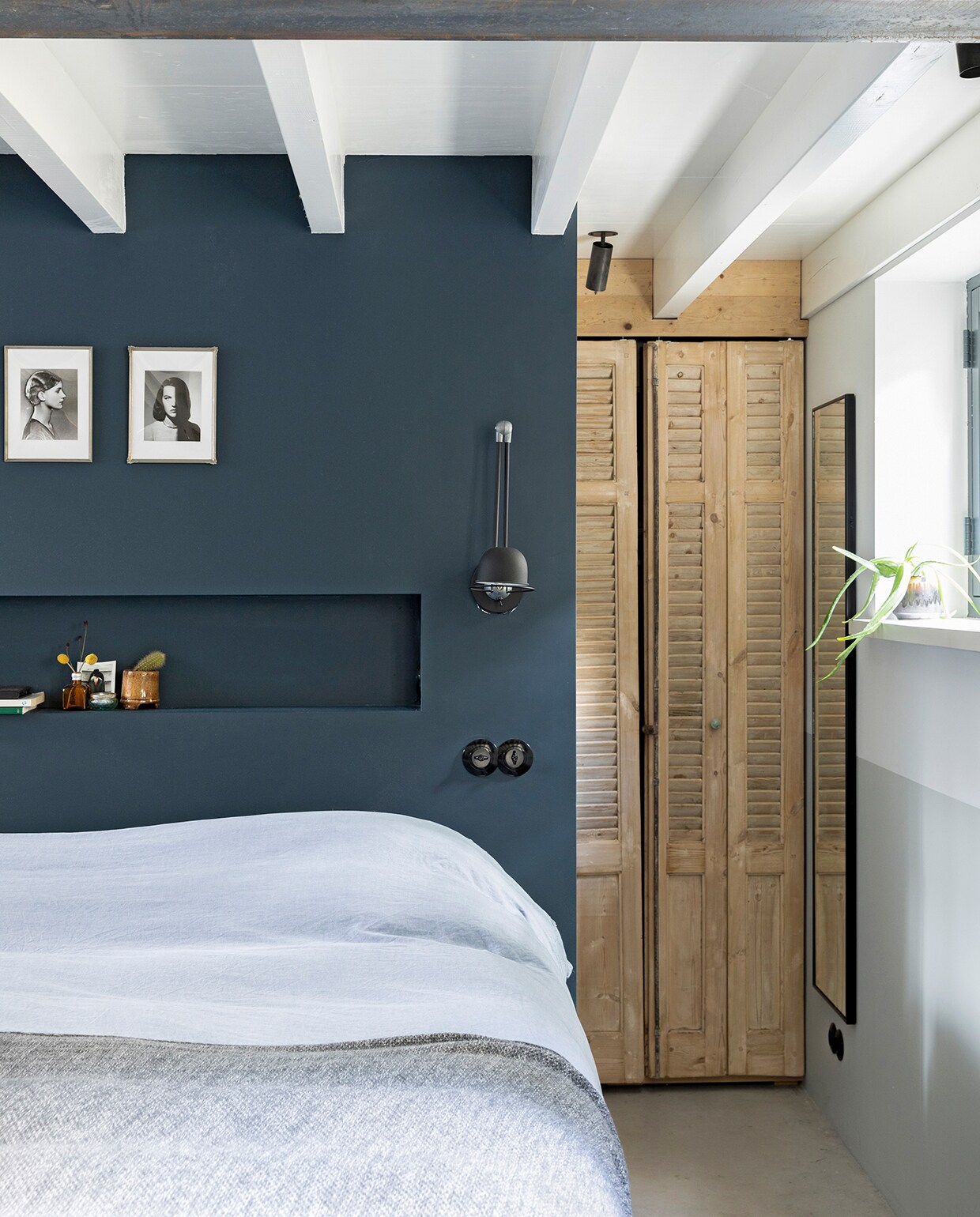 Bouwbedrijf Nagel uit Westbroek verhoogde onder meer het plafond van de kelder aan de achterzijde. Achter het bed loopt een lange kastenwand. Bed Swiss Sense. Beddengoed Hema. Wandlamp Lampenconcurrent. Lichtschakelaars Berker by Hager (1930 serie). Foto’s rommelmarkt IJ-Hallen. Spiegel Ikea. Kleur op achterwand Hague Blue (30) van Farrow &amp; Ball. vtwonen 04-2020 | fotografie Margriet Hoekstra
