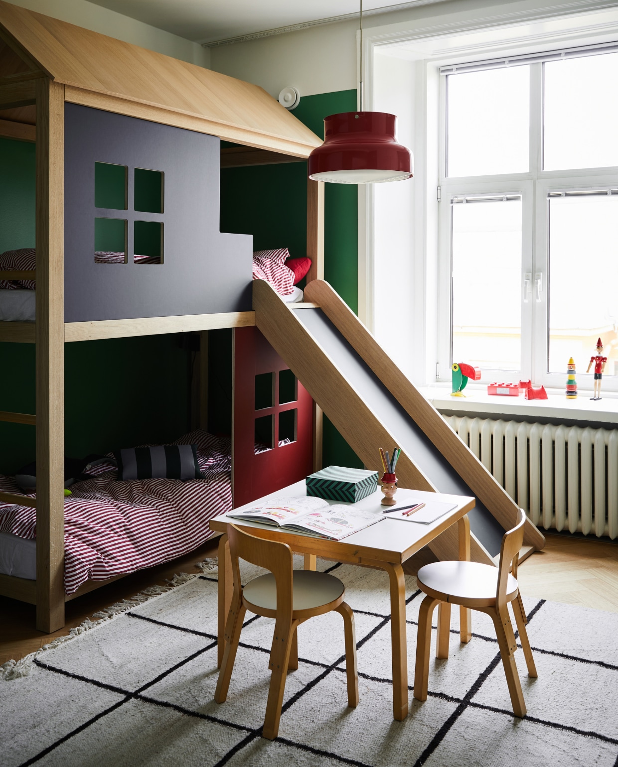 De jongens delen een kamer én een stapelbed-huis, gemaakt door timmerman en meubelmaker Juhan Mikone. De tafel en stoelen van Artek komen uit Annaleena’s ouderlijk huis. Vintage lamp Bumling Ateljé Lyktan. NEE | vtwonen binnenkijken special 12-2022 | Productie KJonna Kivilahti | Fotografie Krista Keltanen/Living Inside | Tekstbewerking Rosa Suikers
