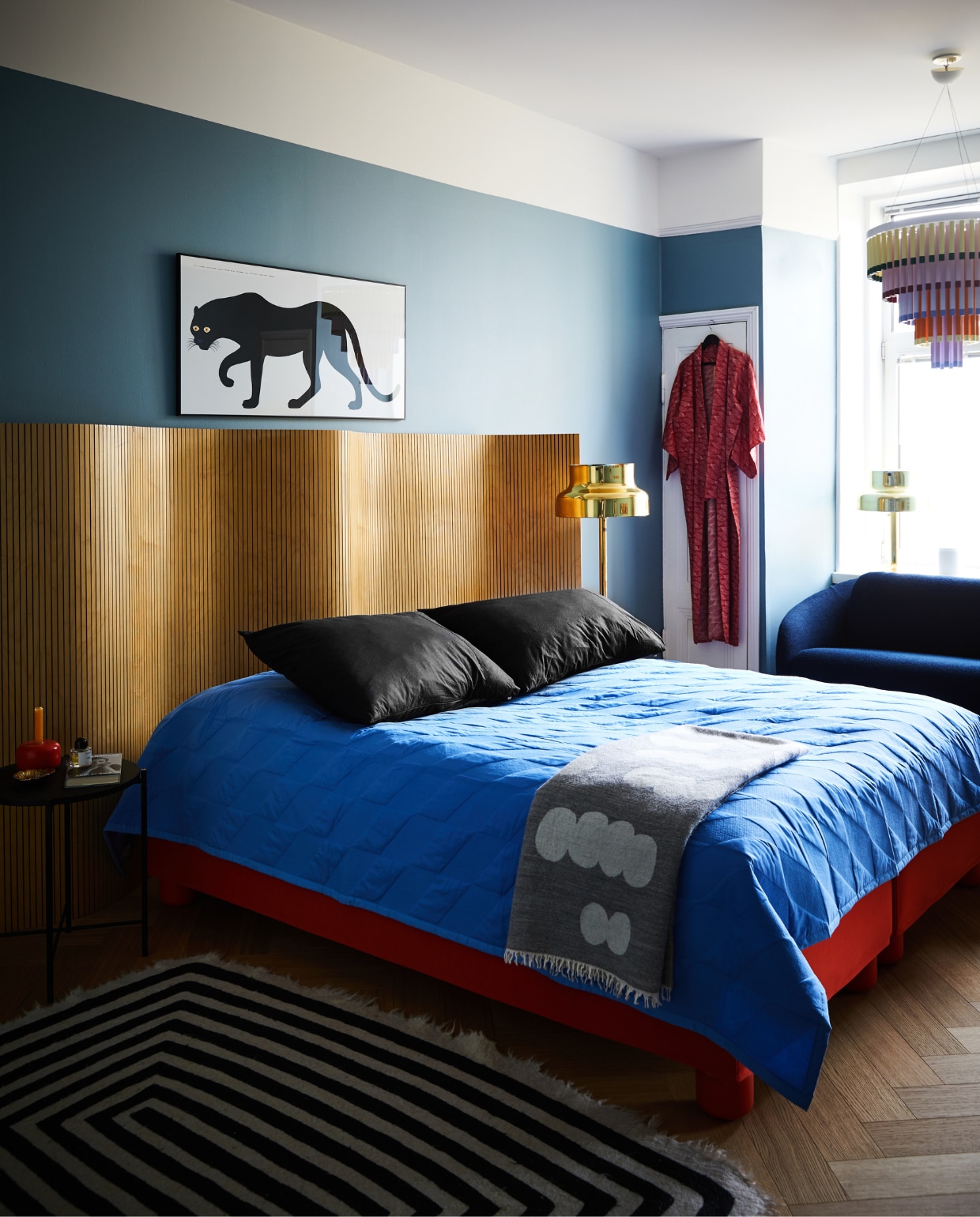 Het hoofdbord is een vintage kamerscherm van Martela. Bedbekleding en poten, bank Jumbo en Kroonluchter Cocktail Hakola. Sprei Kite Quilt Hay. Poster Pantera van Enzo Mari voor Danese Milano. Vintage vloerlampen Bumling Ateljé Lyktan. NEE | vtwonen binnenkijken special 12-2022 | Productie KJonna Kivilahti | Fotografie Krista Keltanen/Living Inside | Tekstbewerking Rosa Suikers