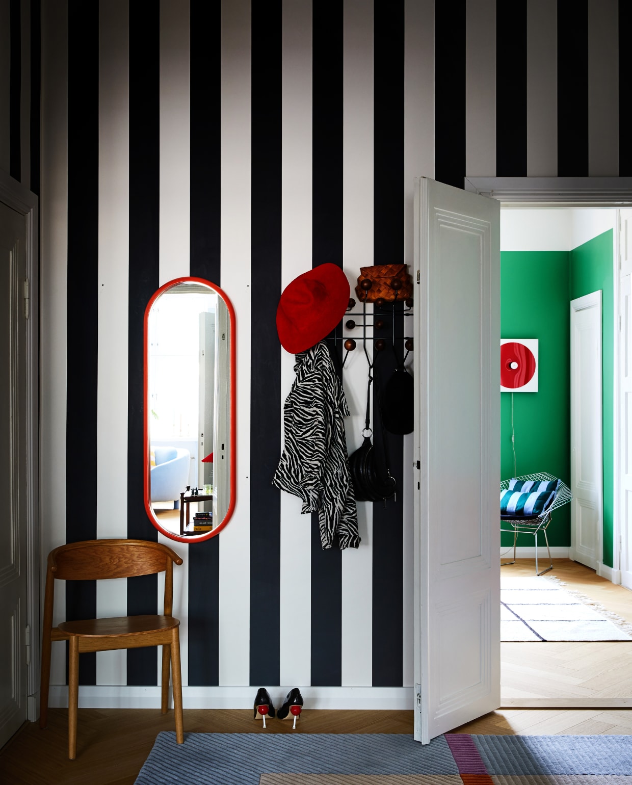 Behang Rand Sandberg. Spiegel Bonbon en stoel Mama Hakola. Kapstok Hang It All Vitra. Vloerkleed xxxxxx. Rode wandlamp w153 Île Inga Sempé. NEE | vtwonen binnenkijken special 12-2022 | Productie KJonna Kivilahti | Fotografie Krista Keltanen/Living Inside | Tekstbewerking Rosa Suikers