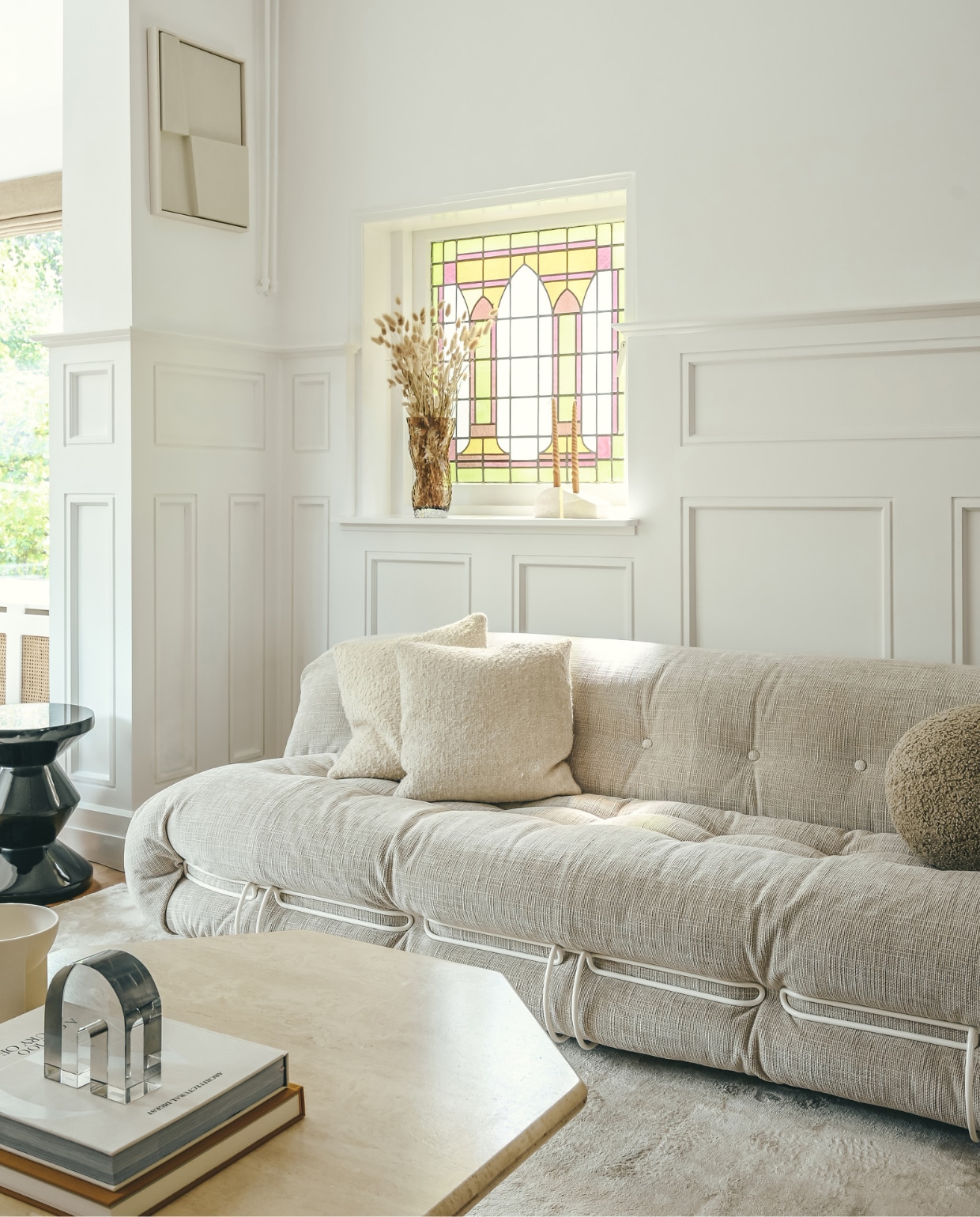 Muurverf Ral 9016. Bank Soriana van Cassina. Vierkante kussens Serax, rond kussen Eichholtz. Kruk Zig Zag van Polspotten. Vloerkleed Jodhpur van Trendcarpet. Salontafel vintage. Keramieken vaas Kuru van Iittala. Glazen object Fést Amsterdam. Vaas op vensterbank Hein Studio. Kandelaars Stoned. Kunstwerk aan de muur Edith Beurskens. vtwonen 01-2023 | styling & fotografie Ellis & Michiel