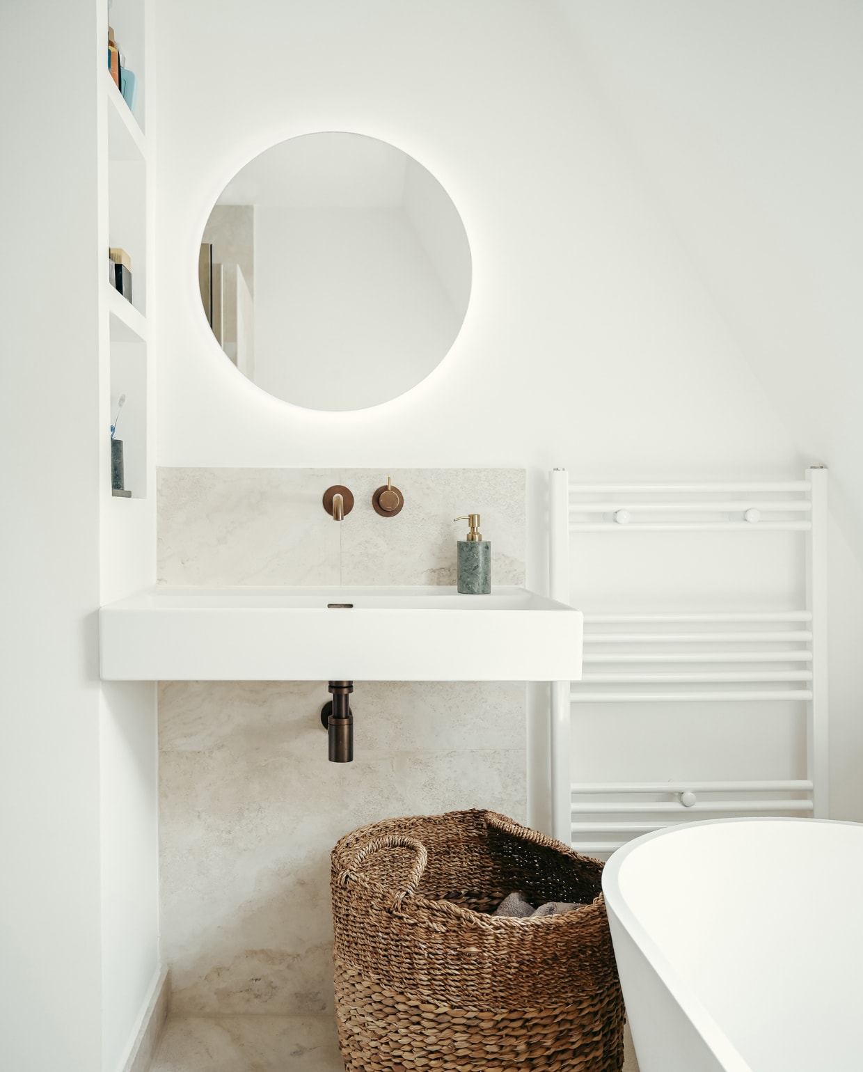Travertin wandplaat en stenen zeeppomp Stoned. Wastafel, bad en spiegel Sanitairwinkel. Kranen van verouderd messing Hotbath. Mand Zara Home. vtwonen 01-2023 | styling &amp; fotografie Ellis &amp; Michiel