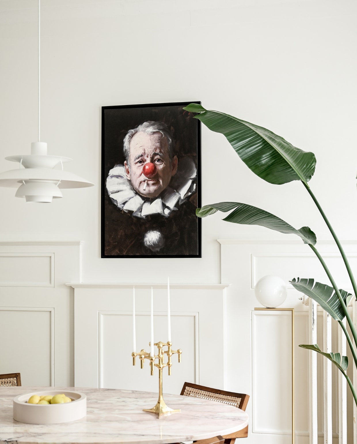 Eettafel en travertin fruitschaal Amphi van Stoned. Stoelen Detjer. Hanglamp PH5 van Louis Poulsen. Vloerlamp Flos. Olieverfschilderij Bill Murray van Tony Pro. Kandelaar Stoff. vtwonen 01-2023 | styling &amp; fotografie Ellis &amp; Michiel
