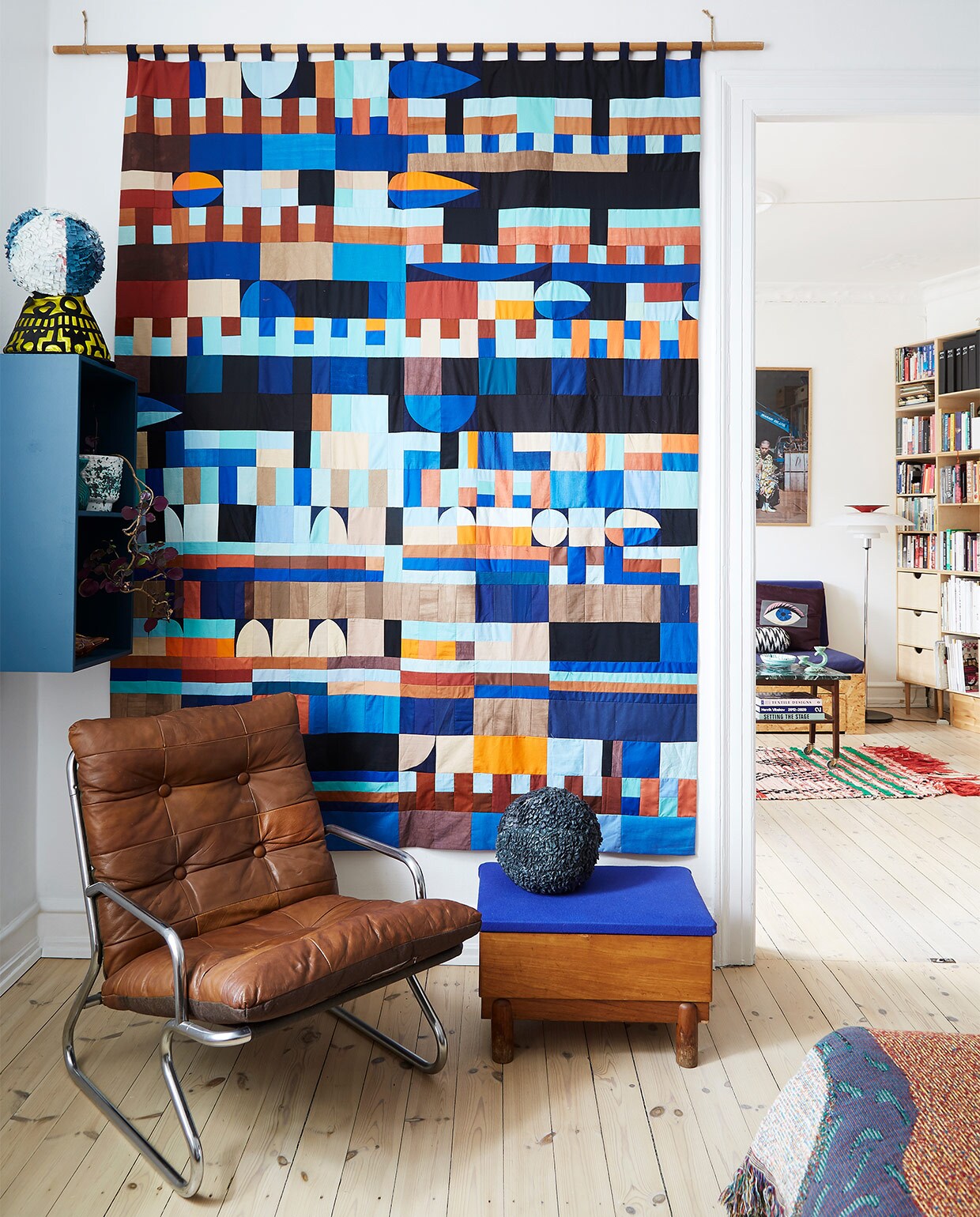 Fauteuil en bijzettafel rommelmarkt. Hangkastje, wandkleed en stoffen ballen zelfgemaakt. vtwonen binnenkijken special 2022 | styling Rikke Graff Juel | fotografie Annita Behrendt
