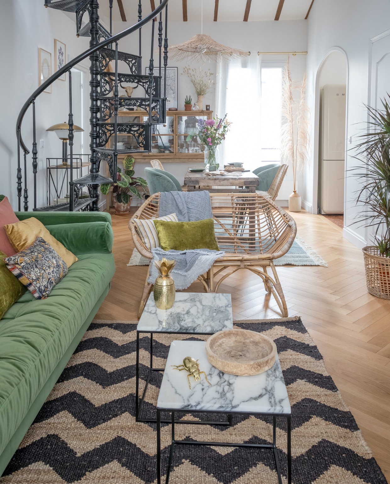 De wenteltrap is op maat gemaakt in Portugal. Bank Made. Salontafels en wandlampen La Redoute. Rotanstoel erfstuk. vtwonen binnenkijken special 121-2022 | productie en styling Marie Maud Levron | fotografie Cecile Perrinet-Lhermitte