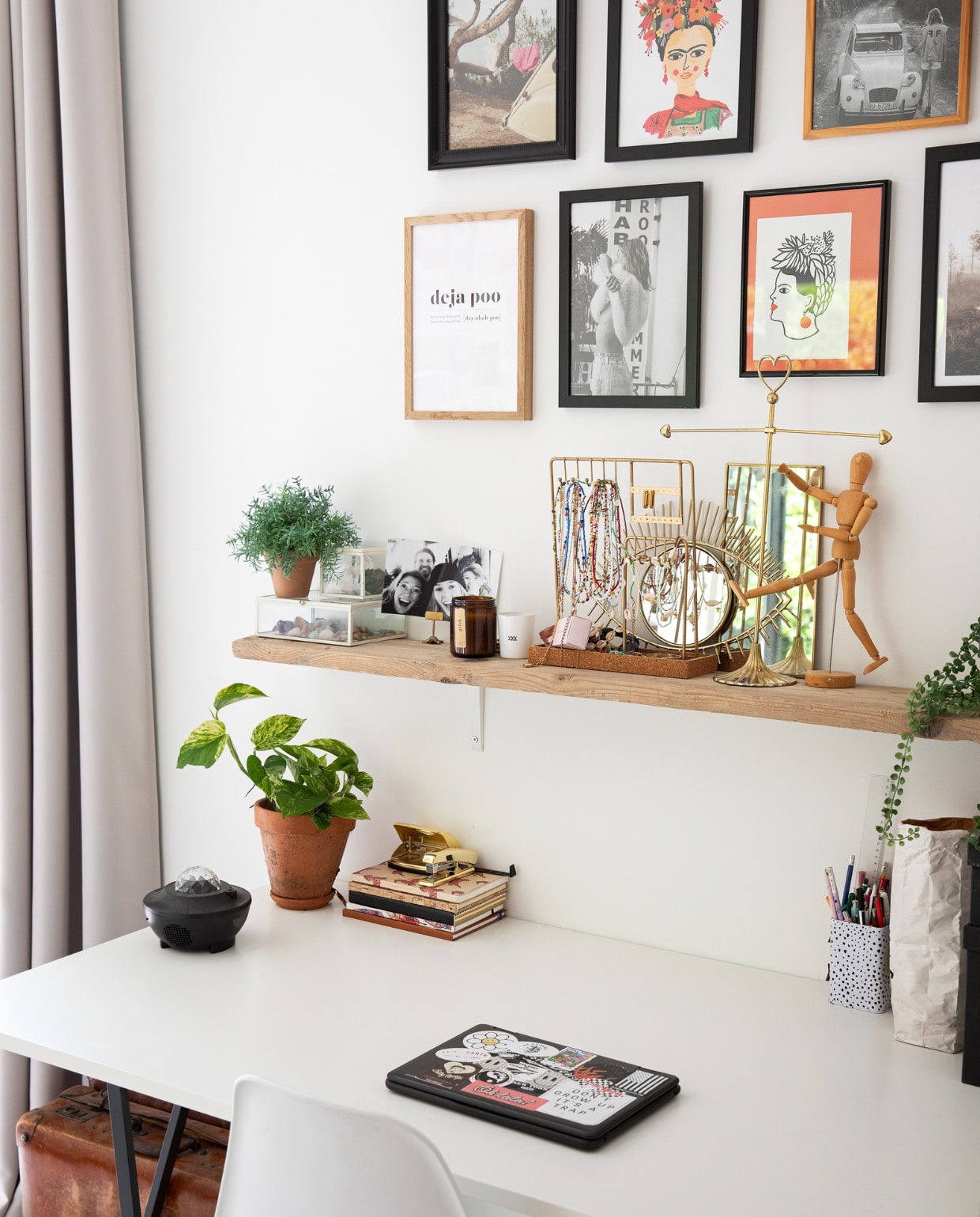 Gordijnen Moondream, muurkleur Ral 9016, lijsten en posters Desenio, foto’s uit tijdschriften, plank Gamma. Op de plank: sieradenhouders uit vintage winkels, spiegels Sissy-Boy, houten tekenpop en planten Xenos. Bureau Ikea, accessoires Hema, stoel Kwantum, koffer van opa. vtwonen 12-2022 | styling Ilona Jongepier | fotografie Dana van Leeuwen