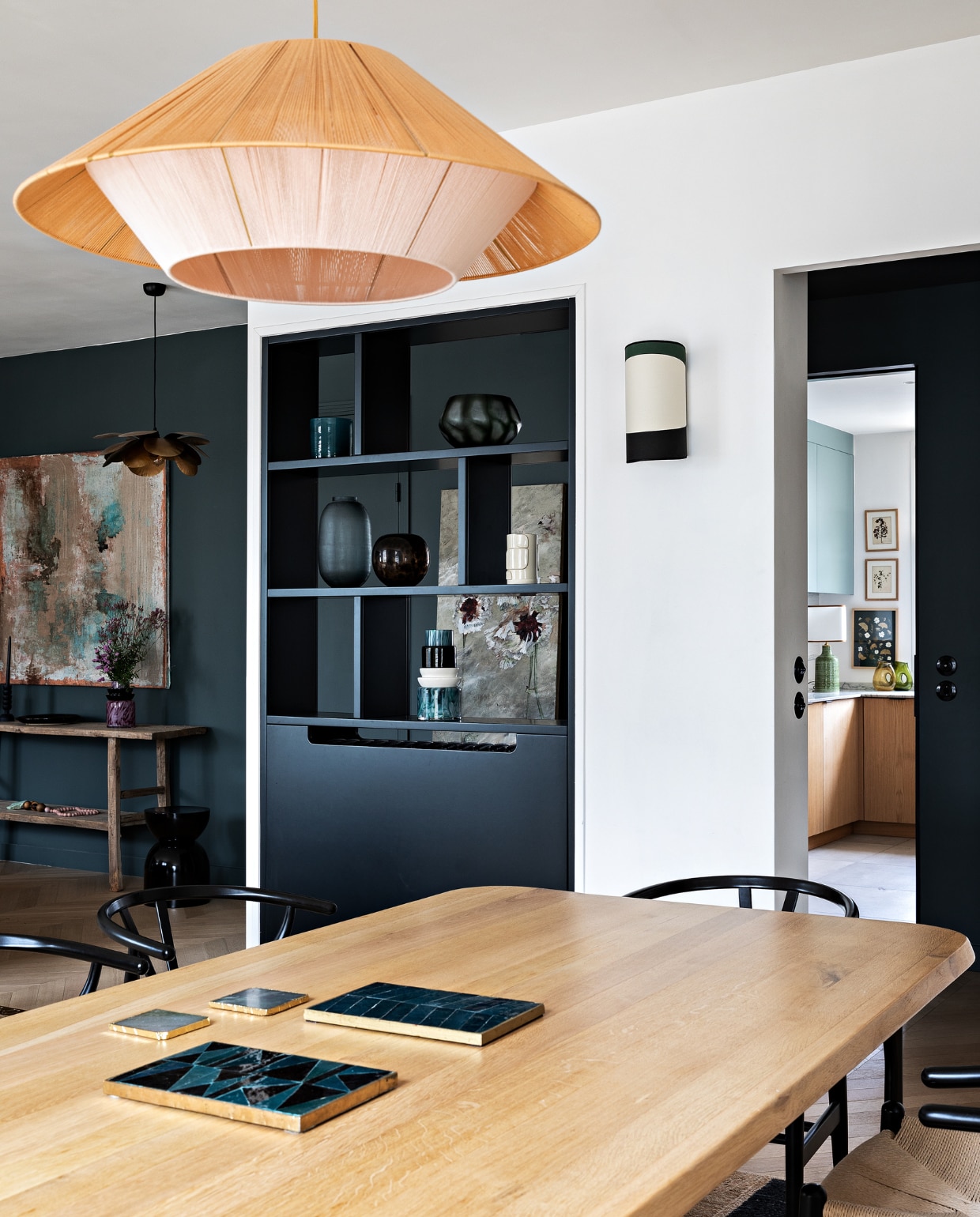 Eiken tafel Oasis en wandlamp Maison Sarah Lavoine. Stoelen Carl Hansen &amp; Søn. Hanglamp Maison Paloma. Open vakkenkast maatwerk. vtwonen 12-2022 | styling Marie-Maud Levron | fotografie Yann Deret