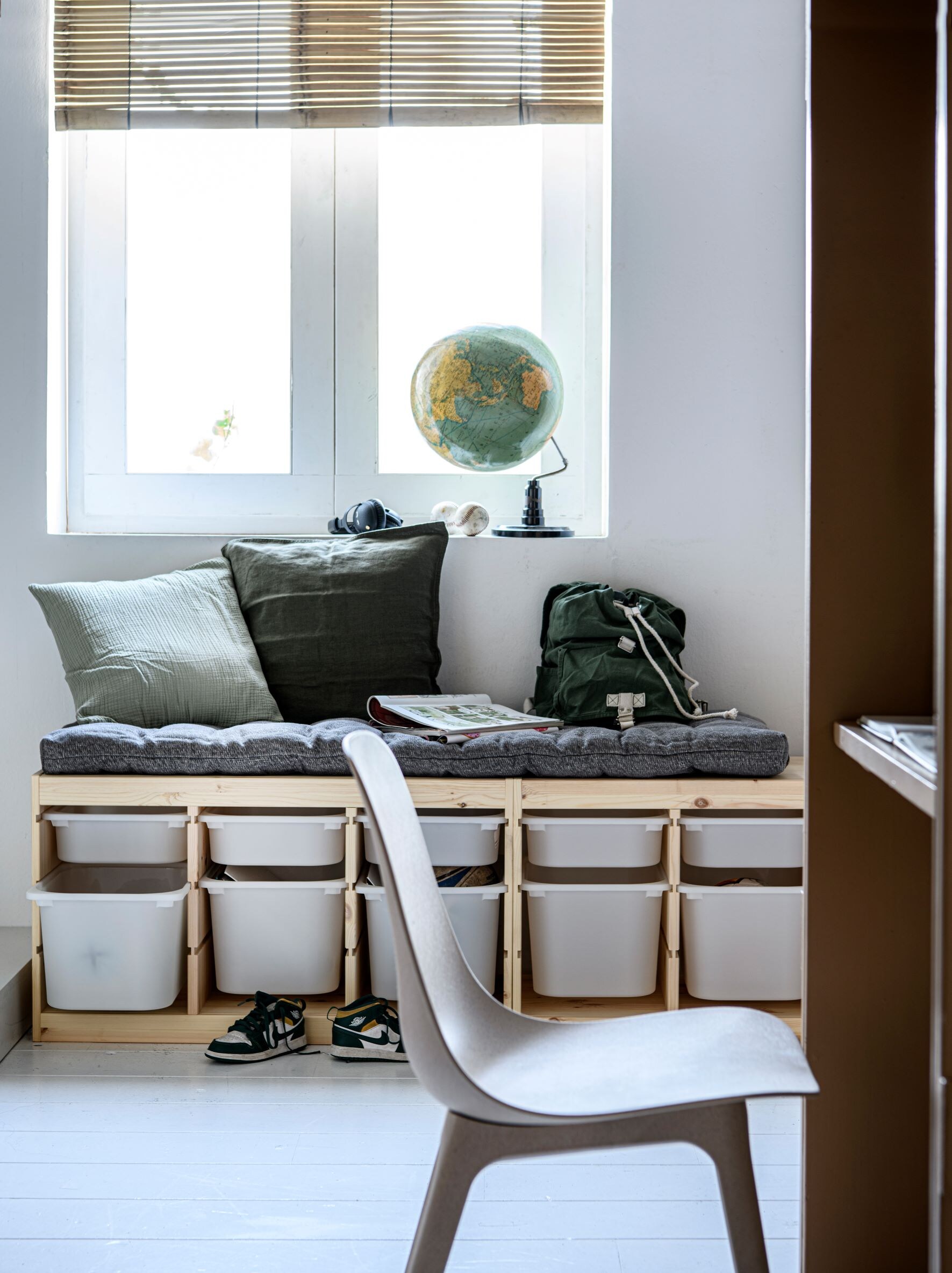 Gebeitst grenenhouten opberg­combinatie Trofast met plastic bakken, 93x44x52 cm (bxdxh) per stuk € 111,95, eetkamerstoel Odger, mix van hout, kunststof en composiet € 79,95 (ikea.nl). Groen mousseline kussen, biologisch katoen, 45×45 cm € 29,94, biologisch katoenen rugzak € 29,95 (dille-kamille.nl). Legergroen linnen kussen, 50×50 cm € 12,99, grijs zitkussen, 50×160 cm € 79,99 (hm.com). Overig privébezit. vtwonen 02-2023 | Styling Marit Saladini, fotografie Louis Lemaire