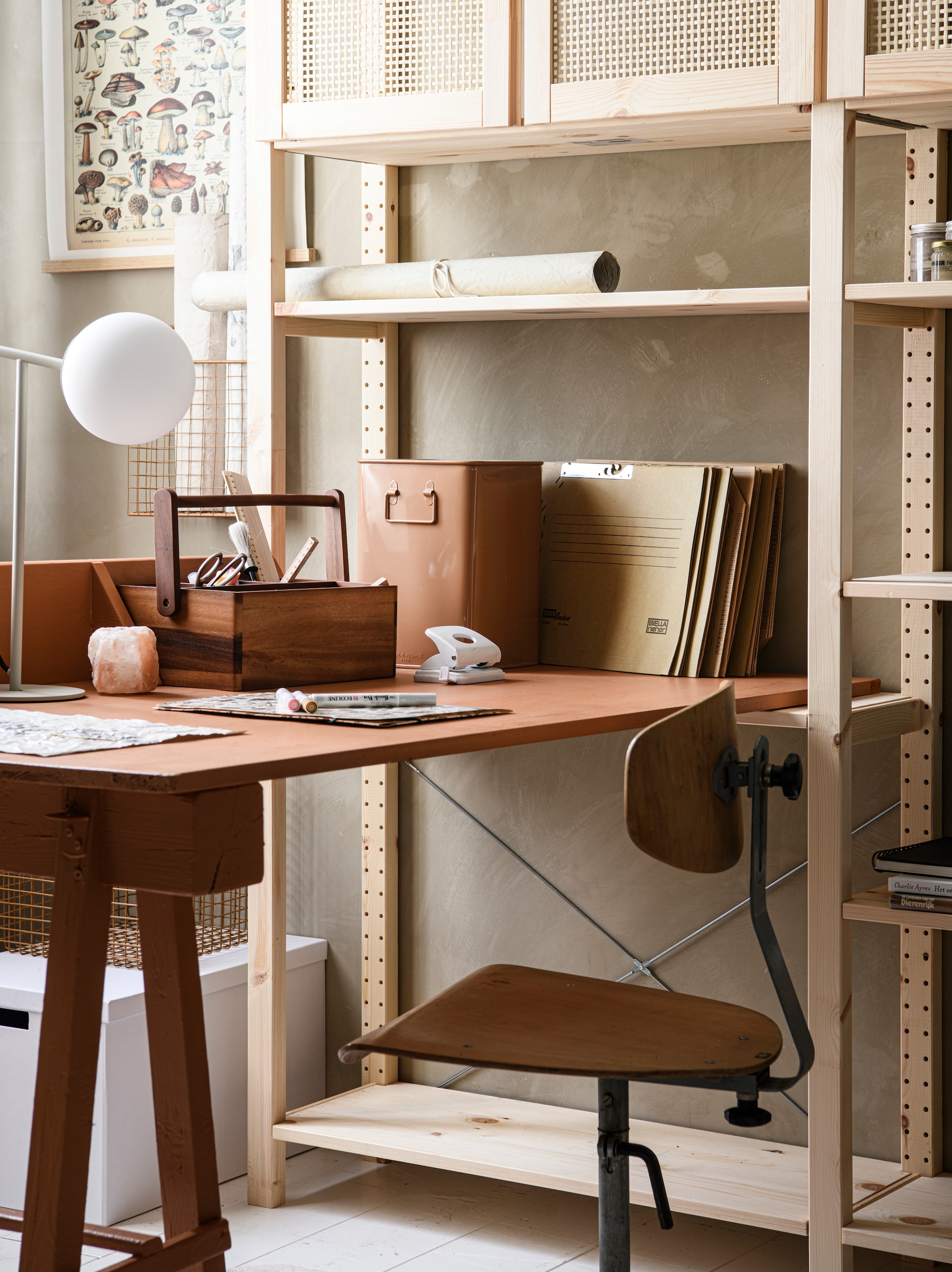 Grenenhouten stellingkast Ivar met 3 elementen/planken, 259x30x179 cm (bxdxh) € 378,-, kastdeuren, 42×83 cm, per 2 € 40,-, totaalopstelling zoals op foto € 459,-, witte gerecyclede kartonnen opbergdoos Tjena, 32x35x32 cm € 4,99 (ikea.com). Limewash muurverf in Caramel, per liter € 30,- (bauwerk.com.au). Wandkleed aan stok Vintage Paddenstoel, 35×47 cm (bxh) € 56,99 (home24.nl). Metalen manden, 24x8x36 cm € 19,99, 32x29x29 cm € 25,95 (zarahome.com). Rollen Old-Dutch canvas Create your Own Canvas, A3-formaat € 17,95 (shop.mo-ca.nl). Vintage bureaustoel, vanaf € 45,-, op maat gemaakt bureaublad met vakken, vanaf € 75,-, box op bureau, vanaf € 35,-, (com-anders.nl). Bureau en box geschilderd met krijtverf Classico in Kenyan Copper van Pure & Original, per liter € 49,45 (pure-original.com). Tafellamp Nox van Loods 5 Goods, metaal en glas € 79,95 (loods5.nl). Acaciahouten opbergbak met 4 vakken en handvat € 24,95, houten meetlat, 20 cm € 2,50 (dille-kamille.nl). Overig privébezit. vtwonen 02-2023 | Styling Marit Saladini, fotografie Louis Lemaire