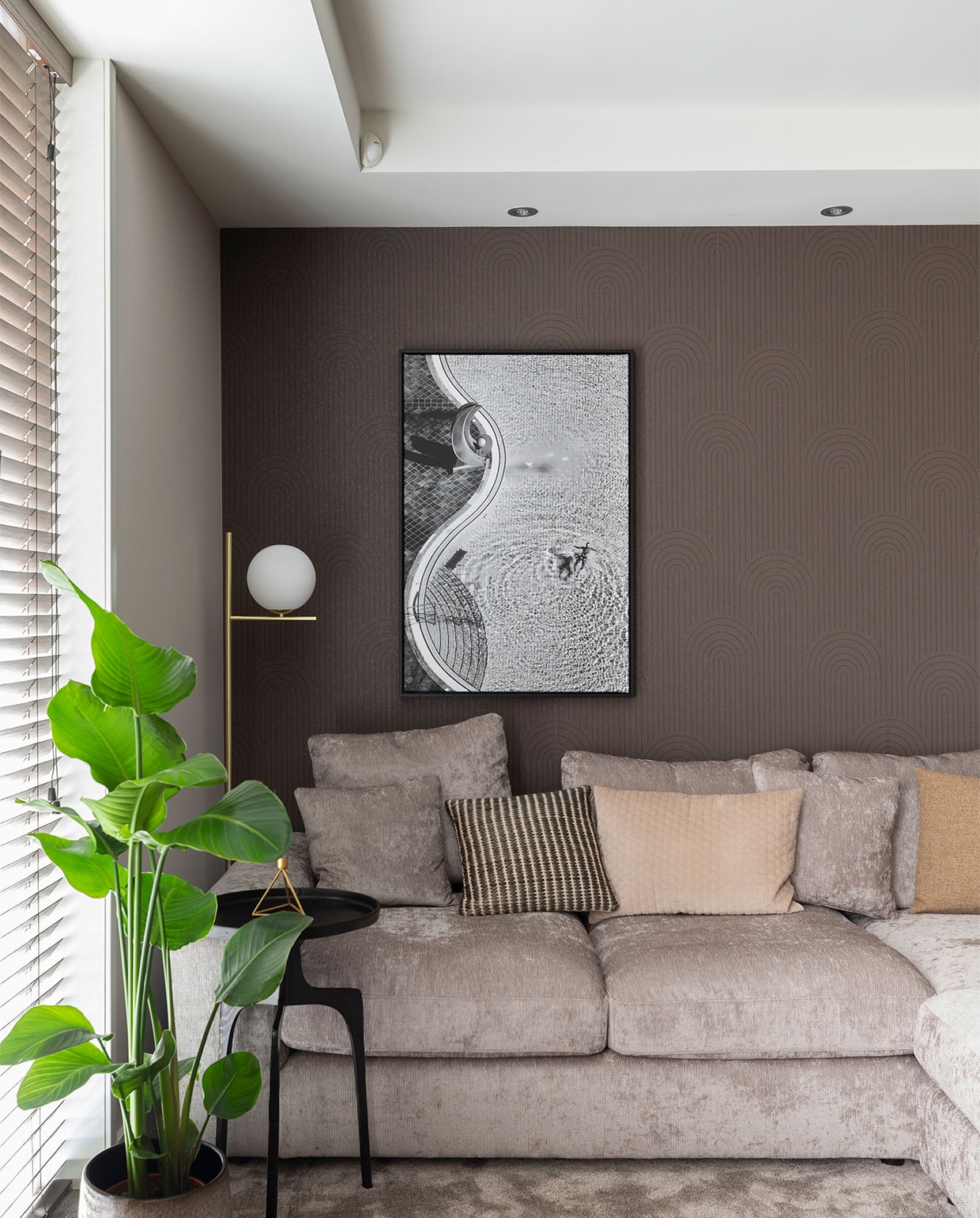 Flexa Creations muurverf Sandy Steps (flexa.nl). Bamboe jaloezien kleur 1523, prijs op aanvraag, vloertapijt Ambiant Boston Mokka 0610, prijs op aanvraag (woninginrichting-aanhuis.nl). Kunstwerk Zwembad van Jure Kravanja, in deze uitvoering ? 261,- (werkaandemuur.nl). Behang Artifact 312436, prijs op aanvraag, gordijnen Patience 7137-3, prijs op aanvraag (eijffinger.com). Gordijnen op maat gemaakt, prijs op aanvraag (gordijnprodukties.nl). Vloerlamp Pure van Trio ? 124,99, salontafel Blackhill van Kave Home ? 159,- (vtwonen.nl). Tv-dressoir prijs op aanvraag (remmers-design), in Flexa Creations verf Sandy Steps (flexa.nl). Bijzettafel Pano van Lightmakers, maat S ? 79,99, maat M ? 179,-, hoekbank Couchbuddy van Eijerkamp Collectie ? 4584,-, kussens vanaf ? 6,99, ronde poef Claudi ? 249,-, op tv-dressoir vaas van Trendhopper ? 10,49, vakkenkast Bright van Eijerkamp Collectie ? 2659,-, in de kast porseleinen opbergbus met print ? 94,95, theepot van Trendhopper ? 29,99, taupe dienblad van Trendhopper ? 69,99 (eijerkamp.nl). Op bijzettafel kandelaar Triangle van Housevitamin (housevitamin.nl). Plant naast bank Strelitzia ? 79,50, pot ? 59,50, plant naast kast Ficus Altissima inclusief pot ? 65,-, bloemen prijs op aanvraag (bloemenweelde-amsterdam.nl), plant bovenin kast inclusief pot ? 14,50, vier kleine planten inclusief potten ? 11,50, pannenkoekenplant inclusief pot ? 17,50 (bloemenweelde-amsterdam.nl). Overig privbezit.