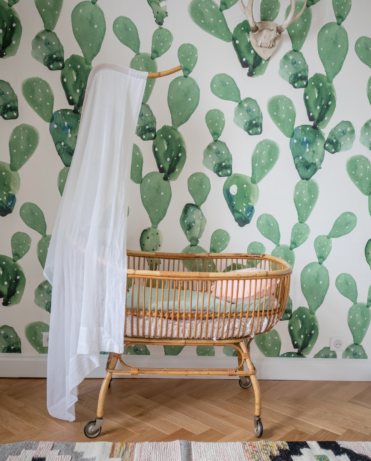 De wieg is een familiestuk. Behang Ane Wall. vtwonen binnenkijken special 121-2022 | productie en styling Marie Maud Levron | fotografie Cecile Perrinet-Lhermitte