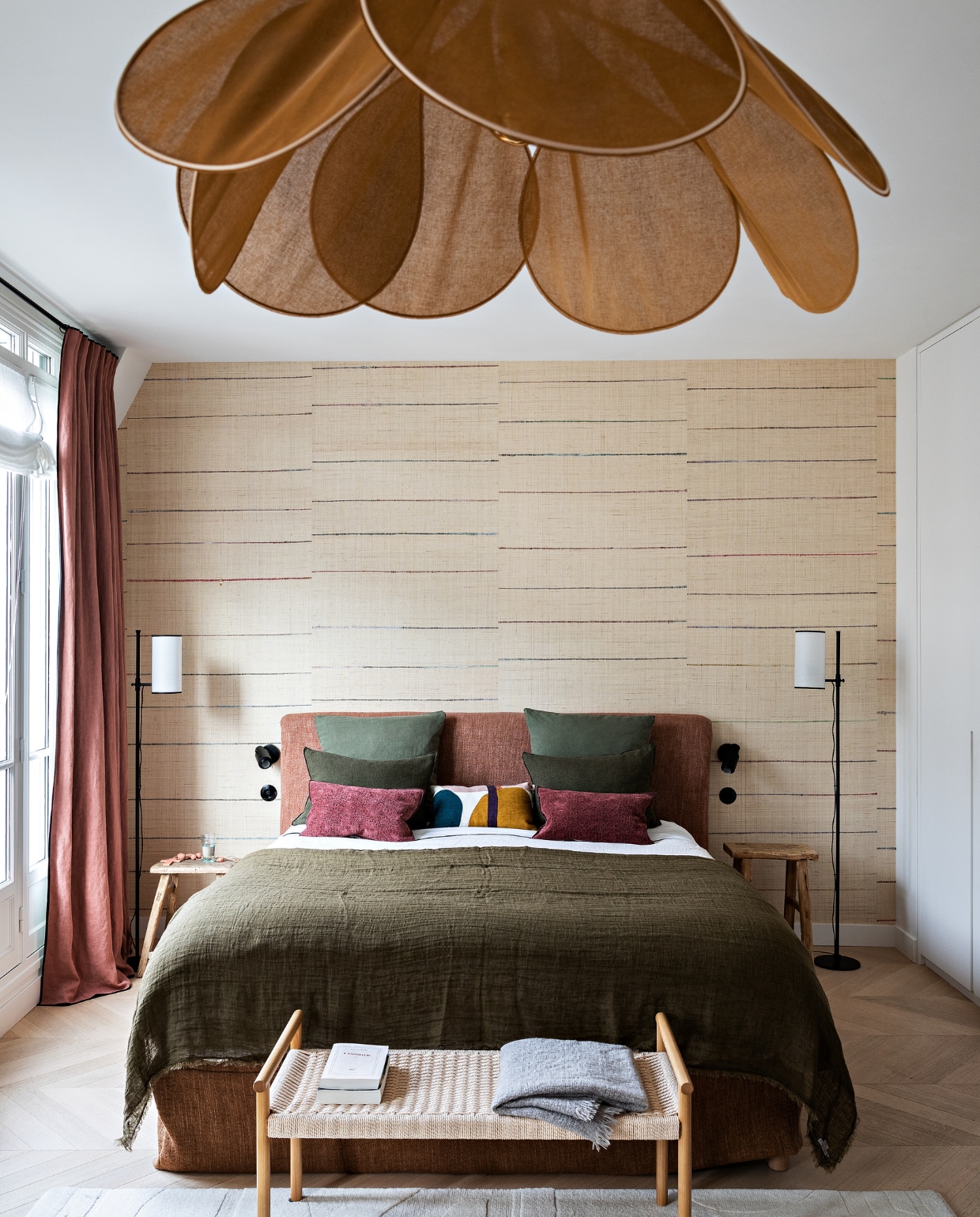 Hoofdeinde, plaid, velours kussens en gordijnen Maison de Vacances. Grafisch kussen La Redoute. Raffia wandpanelen Tsarabanjina van Elitis. Vloerlampen Caravane. Bijzettafels La Maison Pigalle. Bank Zara Home. Hanglamp George. Kleine leeslampen DCW éditions. Vloerkleed Toulemonde Bochart. Overig onbekend. vtwonen 12-2022 | styling Marie-Maud Levron | fotografie Yann Deret