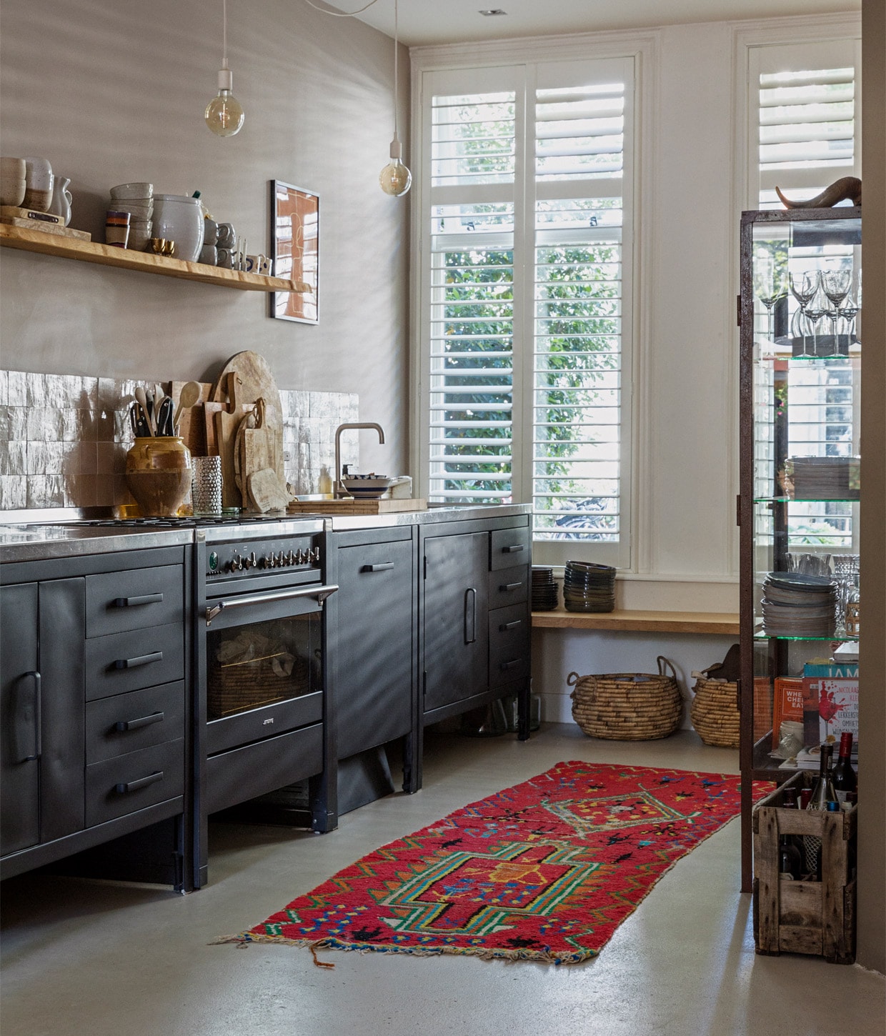 Beeld ter illustratie. De oven afgebeeld is geen oven. Raambekleding, keuken, apparatuur en houten bankje waren al aanwezig, manden onder bankje Leen Bakker, lampen Karwei, vloerkleed The Souks, blauw met witte schaal via de Bijenkorf, servies Dille &amp; Kamille en Villeroy &amp; Boch, houten snijplanken verzameld door de jaren, kruik gevonden op een vintagemarkt in Frankrijk, oranje kunstwerk Atelier Andrea. vtwonen 11-2020 | Productie en styling Ilona Jongepier | Fotografie Dana van Leeuwen | Tekst Anna van der Heijden