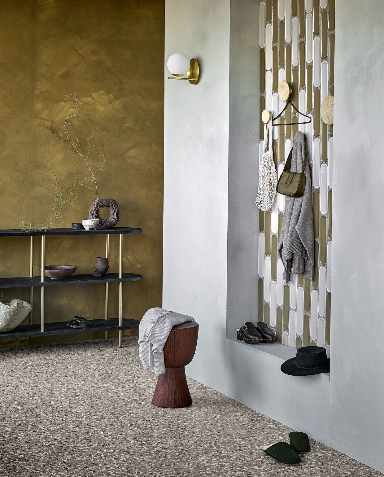 Wandtegels Shapes Greige Round glans, 7,5x30 cm per m² € 68,99, wandtegels Shapes Olive Round glans, 7,5x30 cm per m² € 68,99, vloertegels Terrazzo Clay Flakes, 90x90 cm per m² € 78,-.M.m.v. vestingh.nl (muurverf Lab Paint in Mist, muurverf achterwand Lab Paint in Hunter), loods5.nl (kast), polspotten.nl (houten kruk Tam Tam), vtwonen.nl (wandlamp van Trio, wandhaken van Muuto), hm.com (aardewerken ronde vaas, ronde houten doos, rieten schaal), zarahome.com (bruine vaas, sloffen, messing kledinghanger), zara.com (tas, hoed), mango.com (zwarte klompen). Overig privébezit. vtwonen 02 2023 | productie Tanja Saarberg | styling Sanne Ketelaar | fotografie Peggy Janssen