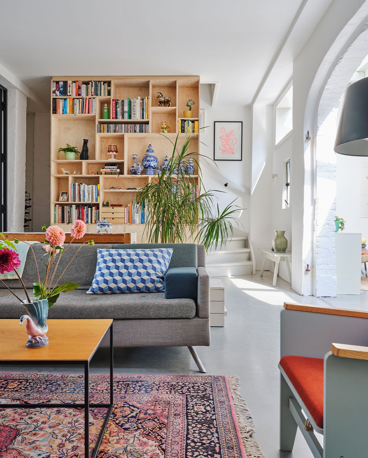 Bank Lot Studio Parade via Vrienden. Geometrisch kussen OXO. Salontafel eigen ontwerp. Fauteuil Katrijn van Floris Hovers via Vrienden. Vloerkleed vintage. Kastenwand op maat gemaakt van Pools grenenhout. Ingelijste prent Trobbies. Wit bankje Piet Hein Eek met daarop de Carter Vase van Floris Hovers via Cor Unum. Overig onbekend. NEE | vtwonen special binnenkijken 2022-3 | fotografie Rene van der Hulst | styling Marloes Wolfs | tekst Caroline Hülsenbeck