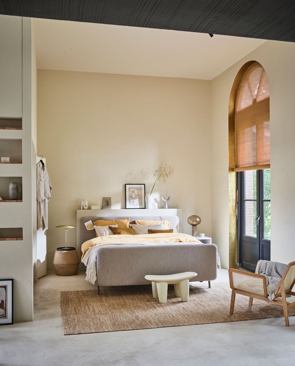 Boxspring Lifestyle by vtwonen Basil vanaf € 1650,- (140x200 cm), verkrijgbaar met verschillende stoffen en kleuren. Hier uitgevoerd met optioneel voetbord, stof Arcade Natural, metalen frame in kleur Champagne en poot Track.M.m.v. vtwonen.nl (goudkleurige lamp van Bolia, vaas van vtwonen, beddengoed Earth in kleur geel uit de vtwonen collectie), anoukb.com (fauteuil en witte kruk, schilderij, vloerkleed), nordal.eu (lamp met glazen bol, marmeren kandelaar, marmeren potje, ecrukleurige kussens), hm.com (linnen pyjama, linnen sprei). Overig privébezit. JA | vtwonen 10-2021 | vtwonen collectie boxspring | productie Tanja Saarberg | styling Cleo Scheulderman | fotografie Jeroen van der Spek | assistentie Krystel Jane Robinson