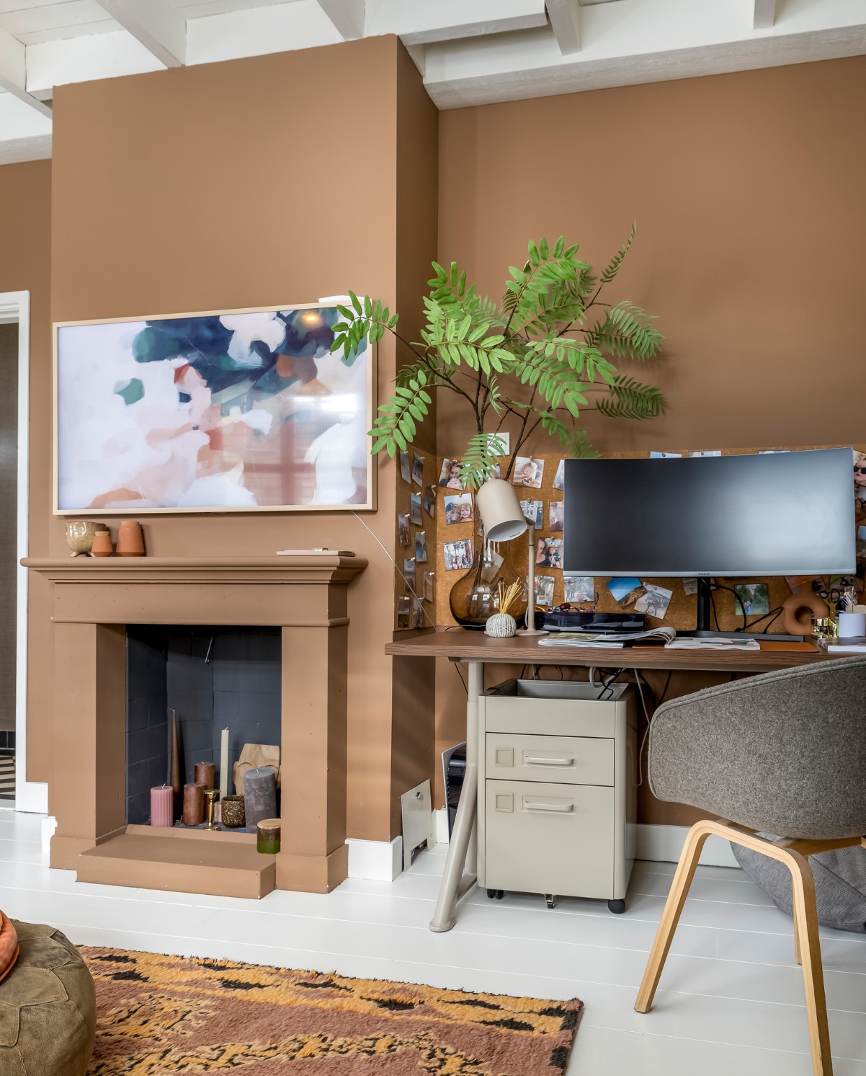 Muurverf Book Room Red van Farrow &amp; Ball. Oude vloer wit geverfd. TV Samsung The Frame. Vaas en potten op schouw Kwantum. Vloerkleed HKliving. Bureau en ladeblok Ikea. Stoel Hay. Glazen vaas MD Living. Plant Jasmijn Bloembinders. Bureaulamp It’s About Romi. Overig onbekend. vtwonen 02-2023 | styling Karin van Schie | fotografie Henny van Belkom