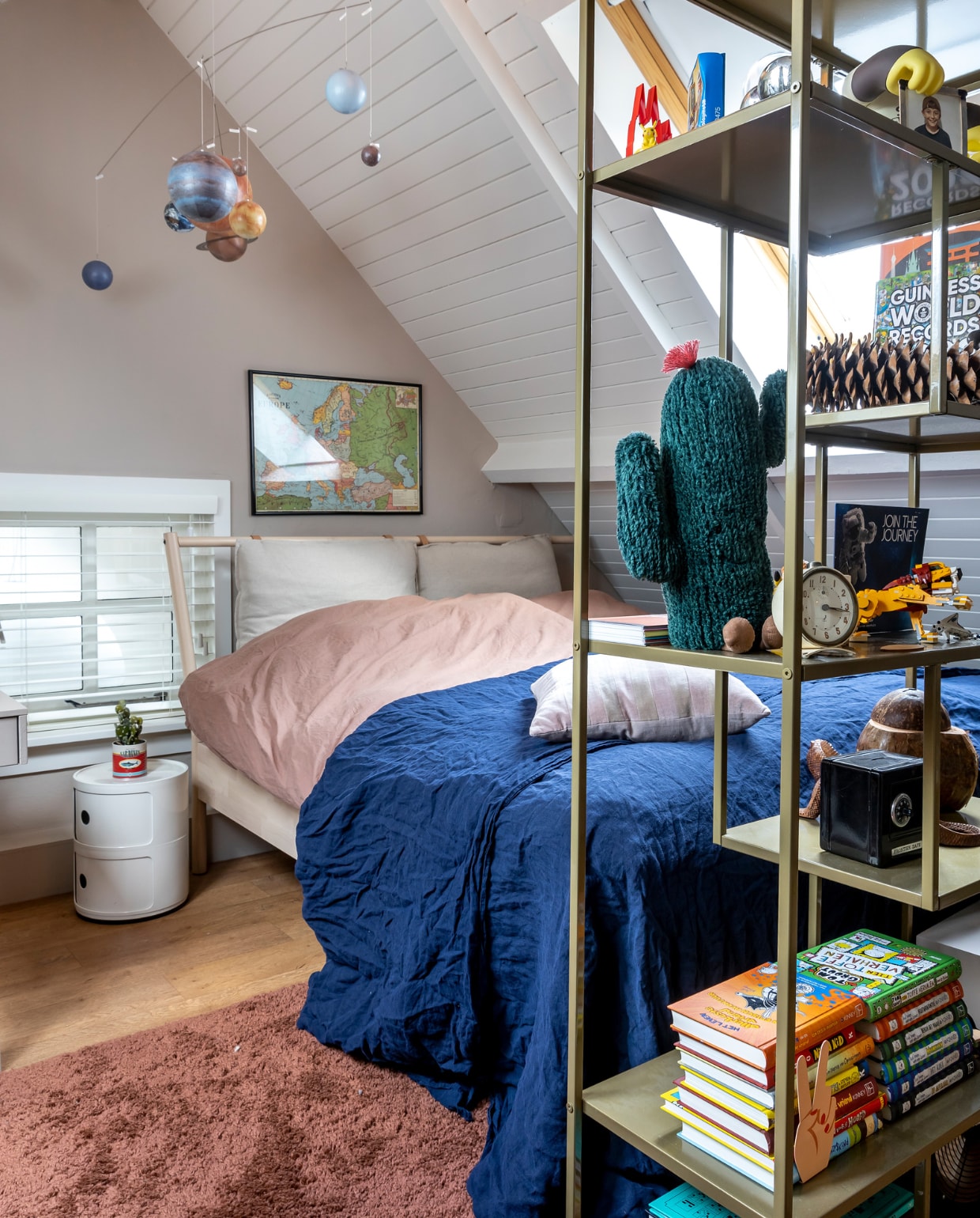 Muurverf Mushroom van Little Greene, verf plafond RAL 9010. Vloerkleed Karwei. Nachtkastje Kartell, bed Ikea, dekbedovertrek Granit. Planetenmobiel Lidor. Kast Karwei. Fotohouder gorilla Sun Bum. Wollen cactus Jellycat. Wekker van oma. Leeuw Lego. Kluisje speelgoedwinkel. Boekenstandaard hand Flying Tiger. Overig onbekend. vtwonen 02-2023 | styling Karin van Schie | fotografie Henny van Belkom