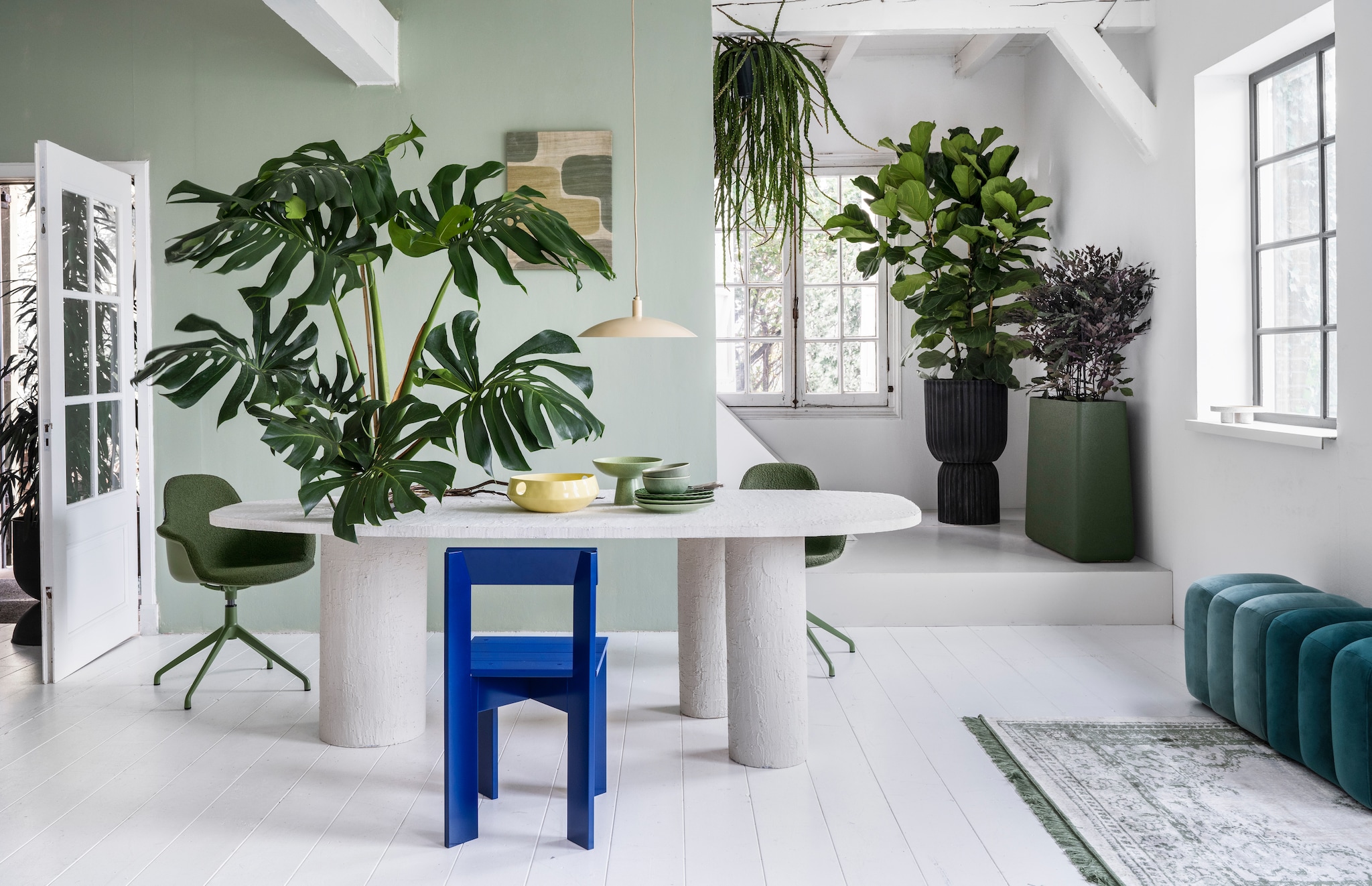 vtwonen 03 2023, groen | Plant op tafel Monstera € 195,-, hangplant Rhipsalis € 44,95, plant achter Ficus Lyrata € 195,-, pot, 45x88 cm (Øxh) € 295,-, plant Hami € 75,-, pot, 80x25x80 cm (bxdxh) € 495,-, achter de openslaande deur treurvijg € 125,- (bydennis.nl). Muurverf in nr. 58 van Lab Paint, 1 liter € 48,- (vestingh.nl). Tafel, prijs en maat op aanvraag (com-anders.nl). Vloerkleed van Zuiver, 240x170 cm, hanglamp van Urban Nature Culture € 119,- (vtwonen.nl). Draaibare stoel Albert Kuip € 349,- (zuiver.nl). Houten stoel Ark Chair van Ferm Living, 40x78x45,5 cm € 199,- (flinders.nl). Zitelementen € 215,- (loods5.nl). Wandkleed € 81,80 (urbannatureculture.nl). Keramieken geribbeld bord, set van 2 € 22,99,-, gespikkelde dinerborden, set van 2 € 26,99, groene keramieken schaal op voet van HKliving € 54,95 (vtwonen.nl), gele fruitschaal van Urban Nature Culture € 59,95 (urbannatureculture.com). vtwonen 03 2023 | styling Marianne Luning | fotografie Stan Koolen
