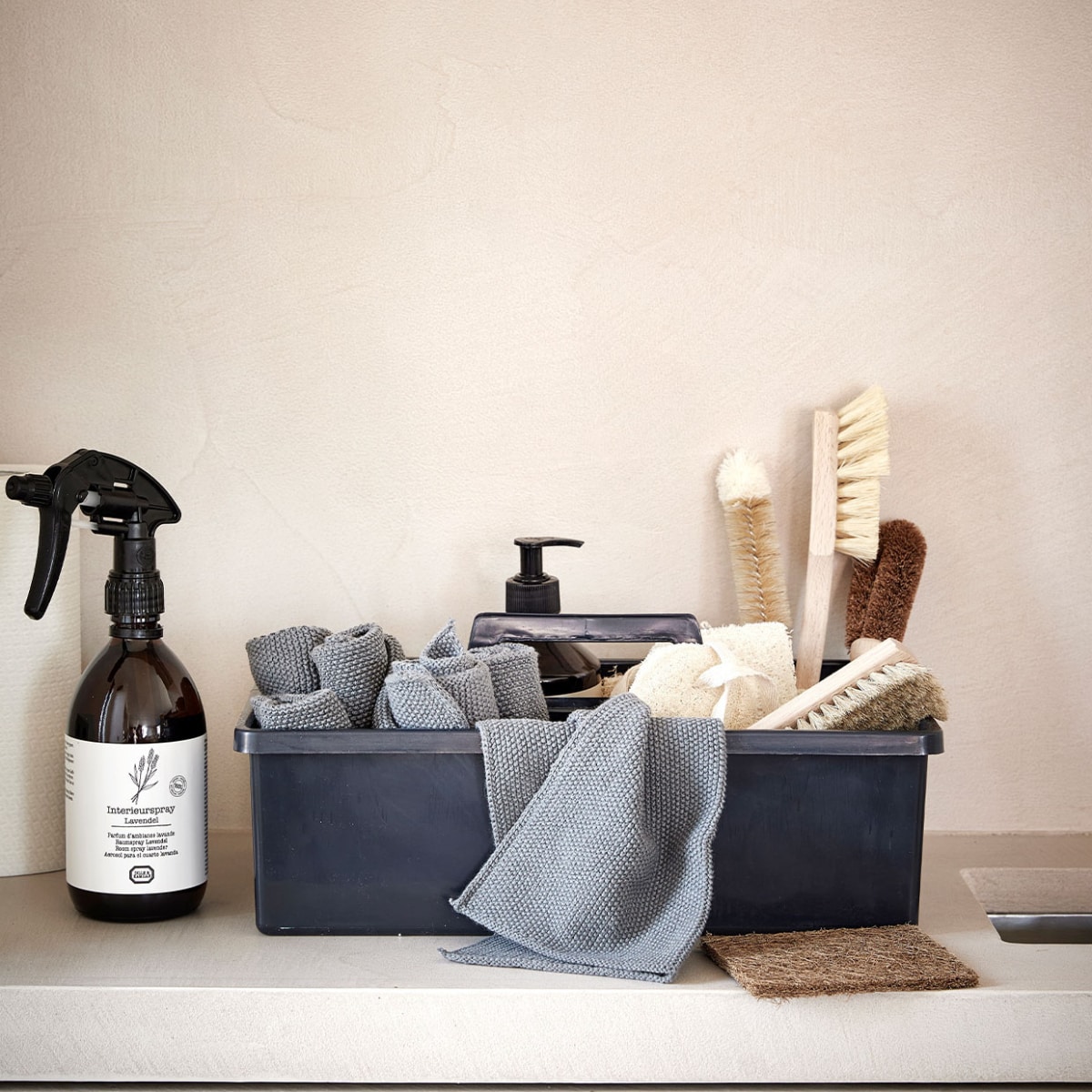 Wasbare katoenen vaatdoeken 3 stuks – blauw/grijs - L 27 x B 27 cm – 16,95 (ZONE.DK), interieur spray lavendel – 500ml – 19,95 - (Dille &amp; Kamille), opberg kistje – donker grijs van gerecycled plastic ( Mijn Stijl), spons loofah – 10cm – 3,95 (Dille &amp; Kamille), schoonmaak sponsje Loofah - 9cm - 4,95 - (Dille &amp; Kamille), Afwasmiddel Cotton - €5,95 (Mijn Stijl), Afwasborstel kokos (Mijn Stijl), borstel – beukenhout – wit -16,5 cm - 2,95 (Dille &amp; Kamille), borstel – beukenhout – 15 cm – 3,95 (Dille &amp; Kamille), bruin kokos/lated pad (Mijn Stijl) vtwonen | styling Studio Marit Saladini | fotografie Peggy Janssen | stylingassistentie Paolo Roseti