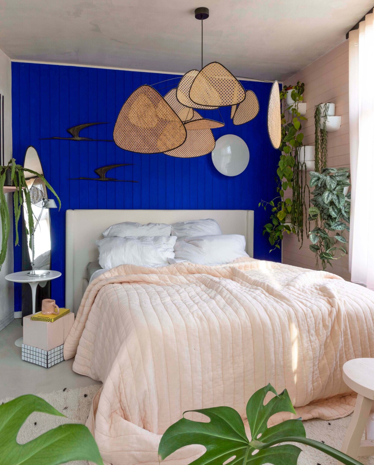 Muurverf Ultra Blue Little Greene. Wandvogels vintage. Witte bijzettafel Tulip Knoll. Roze bijzettafel zelfgemaakt. Kruk zelfgemaakt. Roze mok Siup Studio. Vintage spiegel Lipstick Roger Lecal. Ronde wandlamp Eklipta Louis Poulsen. Hanglamp Screen Market Set. Sprei Crisp Sheets. vtwonen binnenkijken special 121-2022 | productie &amp; fotografie Anne Catherine Scoffoni