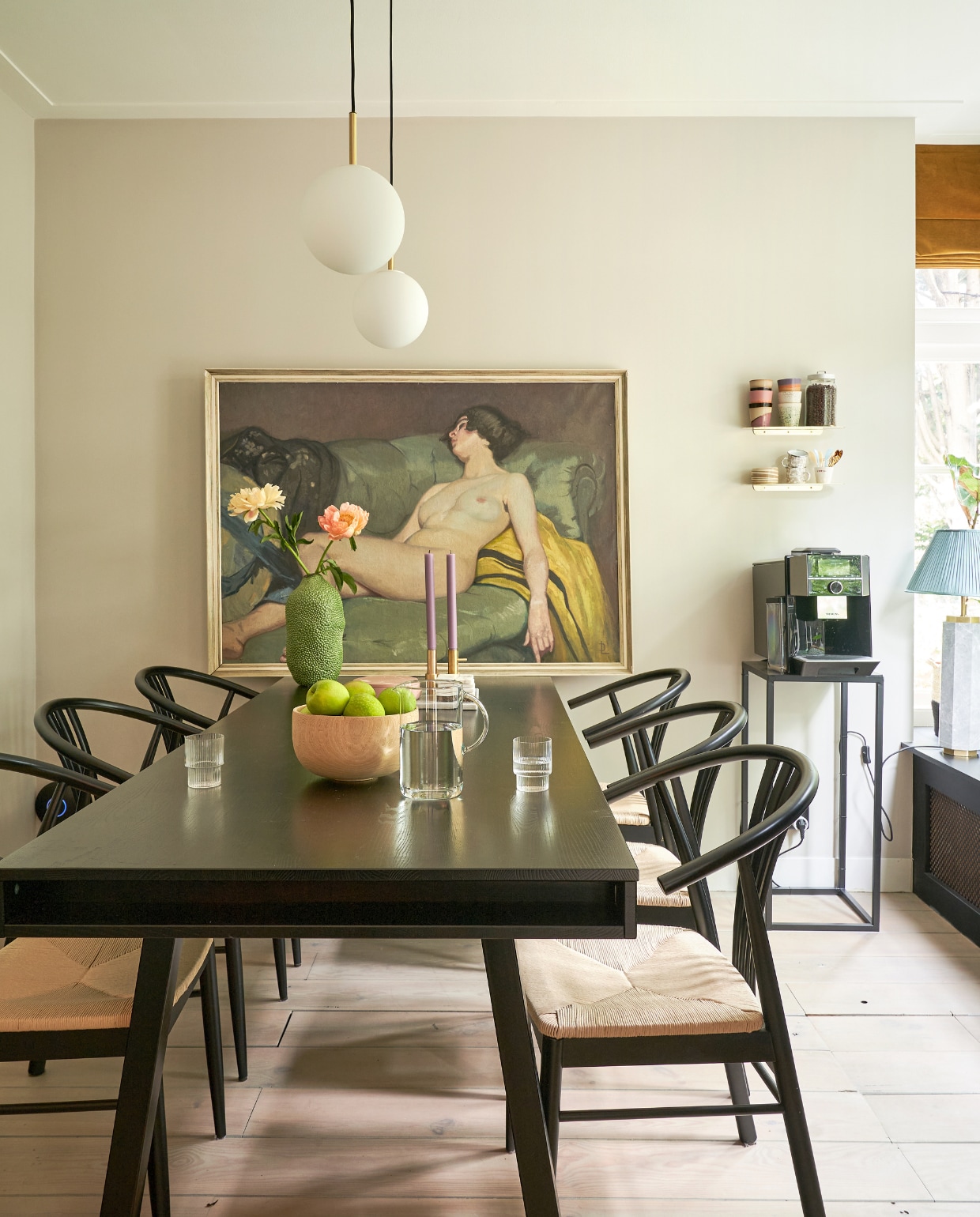 Muurverf Champignon van Gamma, eettafel Trian van Woood Exclusive, kandelaars Fritz Hansen, roze schaal Monday is a state of mind, vaas Jotex, glazen Ferm Living, stoelen fonq, hanglamp Tr Bulb van Menu, schilderij komt uit de familie, wandplankjes Nordal, koppen Atelier van Schaijck en HKliving, zwarte bijzettafel Intratuin, tafellamp Eichholtz, overig onbekend. vtwonen 02-2023 | productie CocoFeatures.com | fotografie Muk van Lil