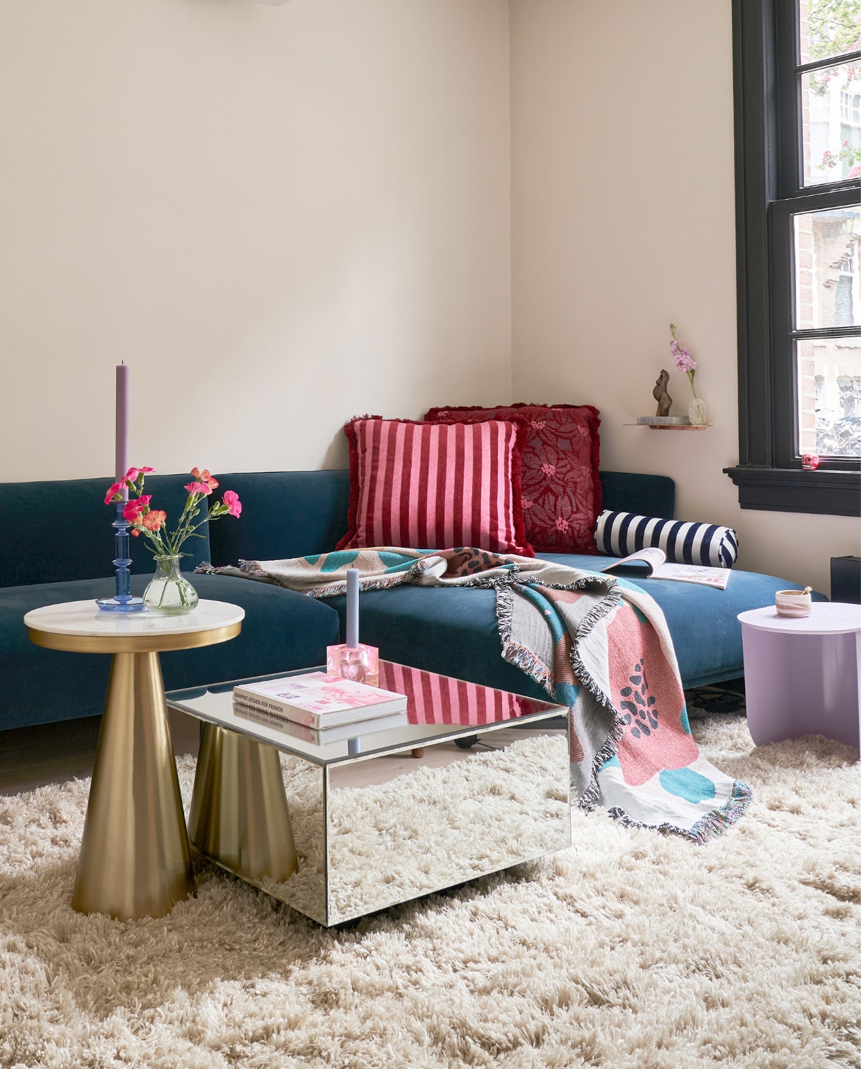 Muurverf Champignon van Gamma, bank, lila bijzettafel en roze kandelaar Fést, kussens Palais, plaid Nox Studio, kopje Atelier van Schaijck, wandplankje Nordal, beeldje BellySisters, vazen H&amp;M Home, marmeren bijzettafel Westwing, blauwe kandelaar Hay, spiegeltafel HKliving, vloerkleed Sissy-Boy. vtwonen 02-2023 | productie CocoFeatures.com | fotografie Muk van Lil
