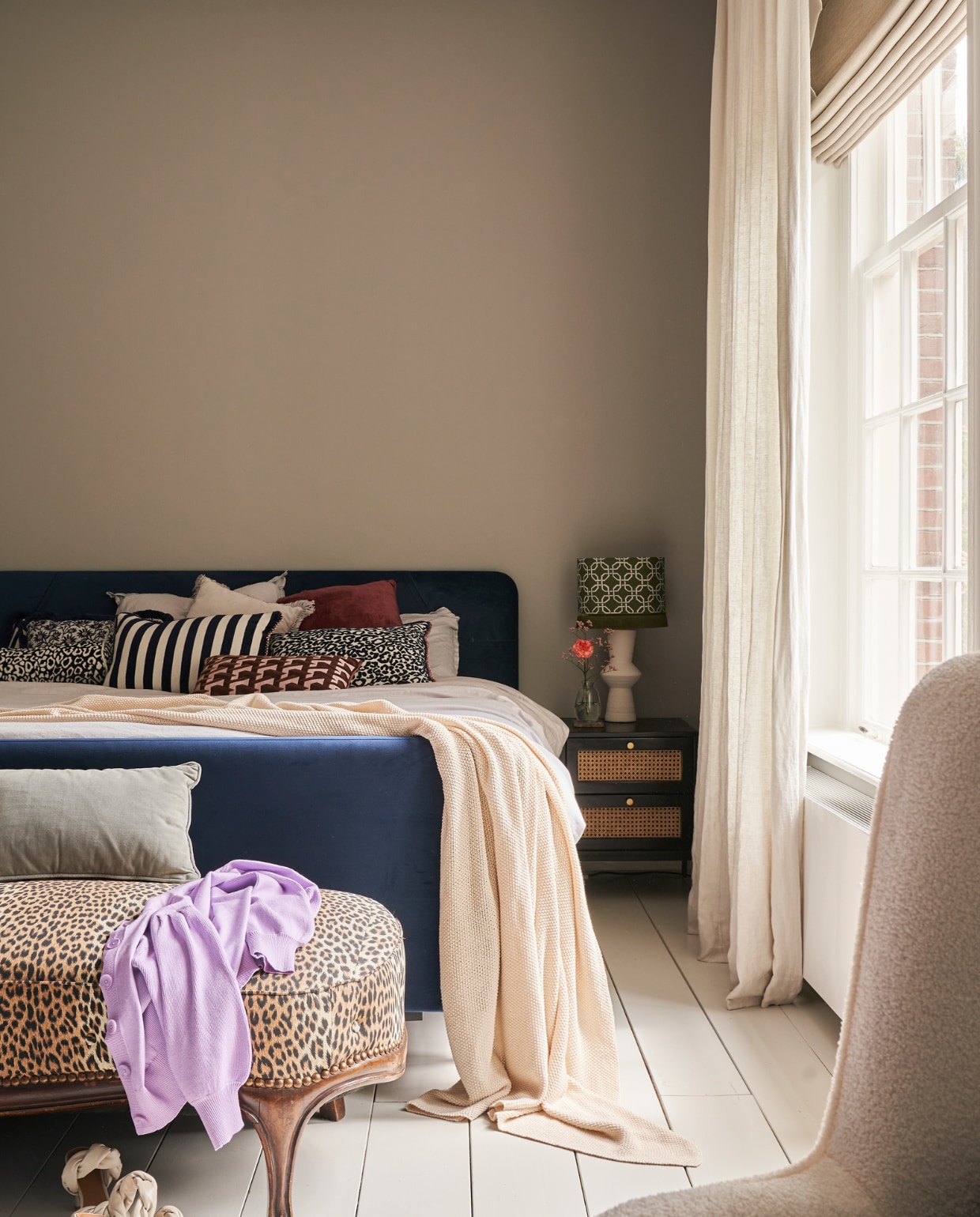 Bed Swiss Sense, dekbedovertrek Cotton Suite, kussens Palais, sprei Beliani, lampenvoet Karwei, lampenkap Palais, bankje panterprint van Emilie’s oma, velours kussen en nachtkastje Westwing, vouwgordijnen Veneta, linnen gordijnen Kwantum, schommelstoel Mama van Furndaily, vloer in kleur Sfinx van Gamma, muurverf Kapel van Gamma. vtwonen 02-2023 | productie CocoFeatures.com | fotografie Muk van Lil