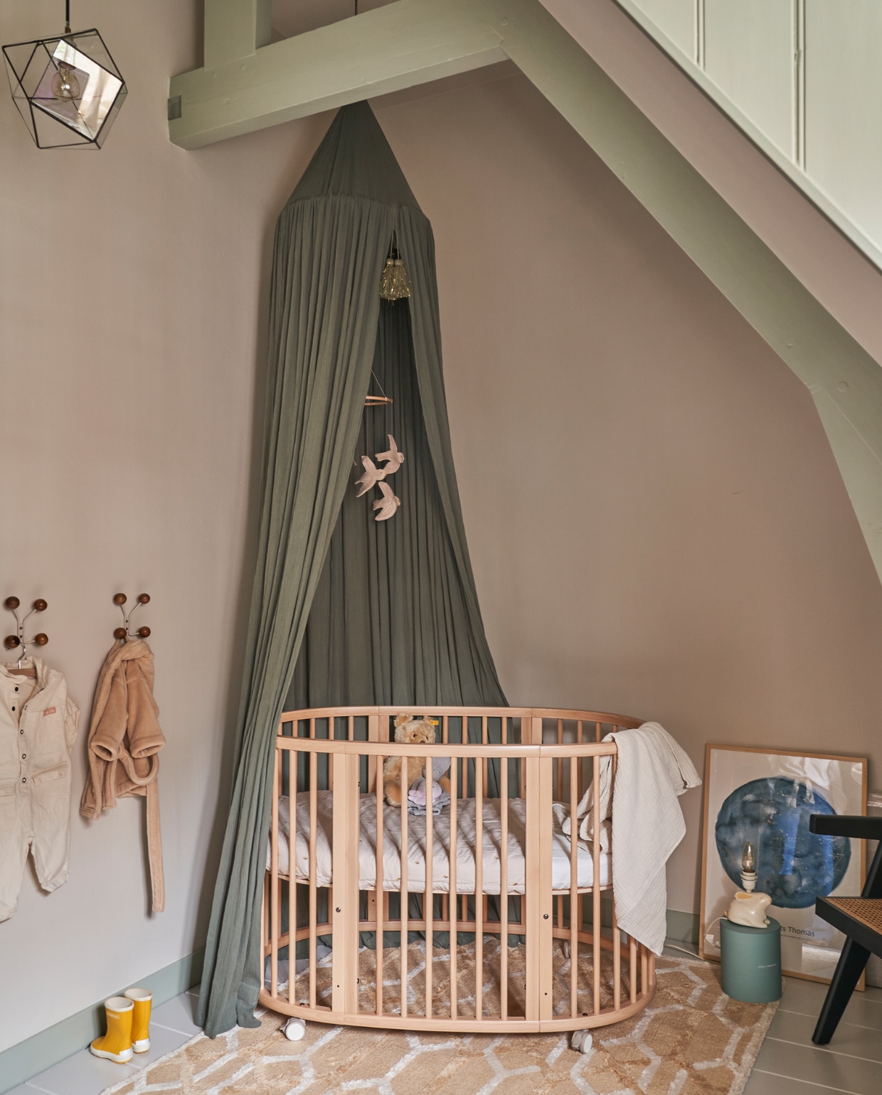 Verfkleur balken Blue Gray, verfkleur muur Skimming Stone, beide Farrow &amp; Ball. Ledikant Stokke, groene hemel Konges Sløjd, beddengoed Garbo &amp; Friends, vilten mobiel Nanami, houten kapstokjes H&amp;M Home, hanglamp vintage, konijnenlamp komt uit Emilie’s kinderkamer, print sterrenhemel boven Amsterdam op het moment van de geboorte van Beer van MrStarsky, vloerkleed Westwing, stoel Woood. vtwonen 02-2023 | productie CocoFeatures.com | fotografie Muk van Lil