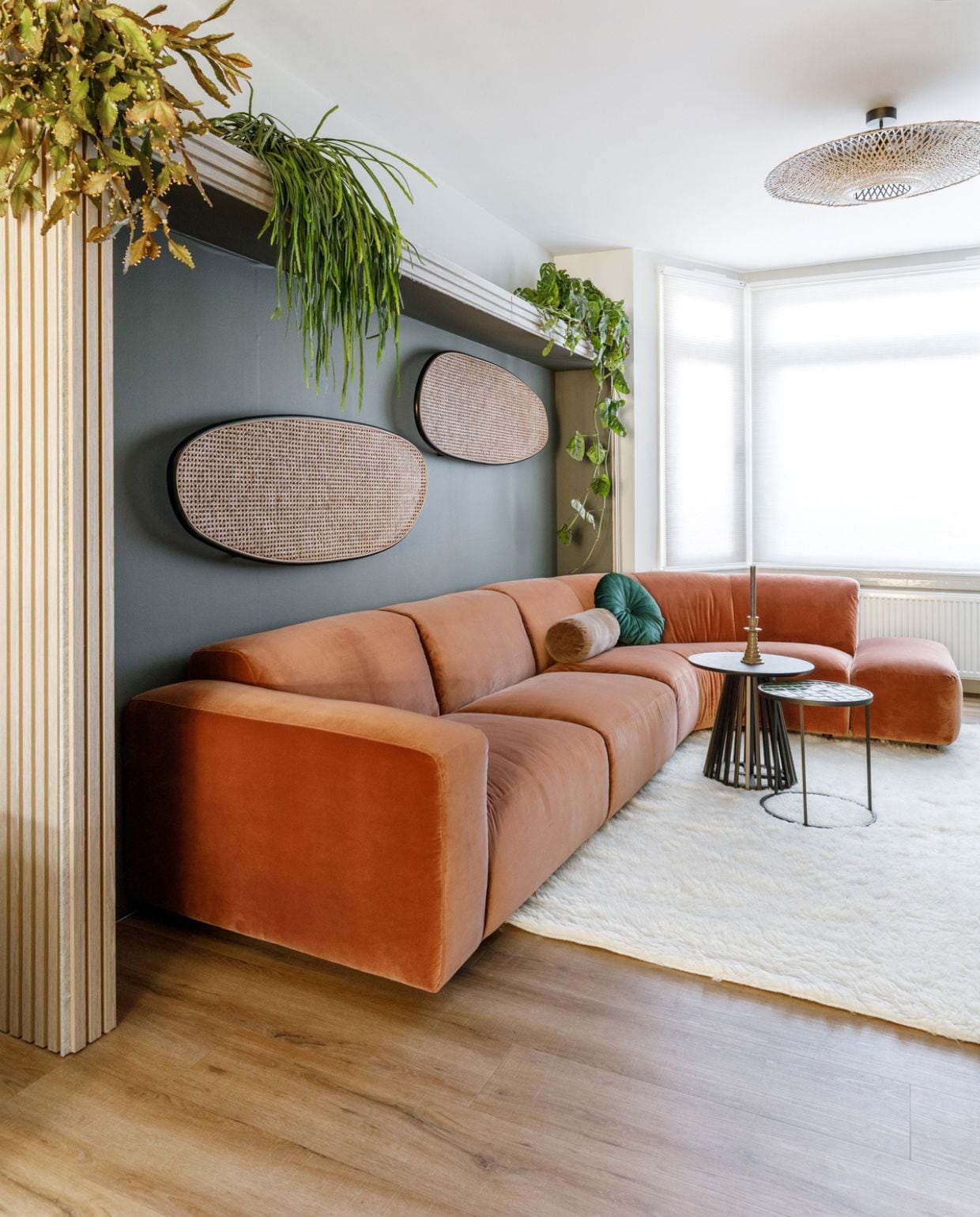 Verf muren Misted Grey en verf nissen Woudgroen van Flexa. Op maat gemaakte plisségordijnen Luxaflex Duette 7732 64 mm Aanhuis.nl. Scharnierdeur naar de woonkamer in de kleur brons GewoonGers. Panelen (als lambrisering en rondom de nissen) gebleekt eiken op grijs vilt Noakk. Elementenbank Abruzzi Eijerkamp. Lichtarmaturen (achter de bank) Sisu light sculptures Rik ten Velden. Vloerkleed Merano in de kleur White Eijerkamp. Zwarte bijzettafel Slats van vtwonen vtwonen.nl/shop. Groene bijzettafel Glazed Zuiver. Groene kandelaars Ceramic van vtwonen vtwonen.nl/shop. Hanglamp Kalimantan Eijerkamp. Bruin rolkussen Cotton Velvet van vtwonen, donkergroen kussen Mandarin van Kaat Amsterdam vtwonen.nl/shop. Weer verliefd op je huis aflevering 2 seizoen 18 | styling Frans Uyterlinde | fotografie Margriet Hoekstra