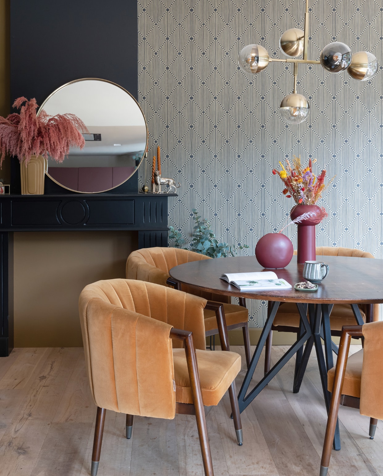 Muurkleur in ‘haard’ Autumn Gold van Histor. Muurkleur op schouw Parcours en vliesbehang De gouden kunst van Sublime via Praxis. Spiegel Curve van Kare Design, vaas op schouw Pt Living, pampasgras in Roest De Gier Bloemen, kandelaars Fést Amsterdam en H&amp;M Home. Kaarsen, mok en tijger Sissy-Boy. Stoelen Tammy van Dutchbone, tafel Studio Henk, lamp Globular BePureHome, vazen op tafel Kwantum, schaaltje HKliving. vtwonen 02-2023 | styling Sharon Roest | fotografie Caroline Martinot | tekst Mirjam Rosema-Verhulst