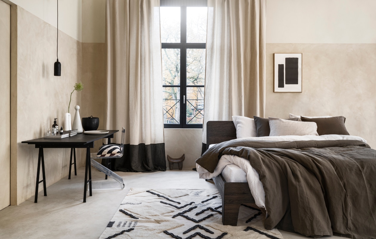 Stucco-look muurverf Mykonos, 2,5 liter € 110,- (wearewowmakers.com). Gordijn gemaakt van linnen Cloud Rider van Chivasso, per meter € 114,50 (jab.de). Bedombouw Pure, eiken fineer in Charcoal olie, 180x200 cm (bxd) € 3400,- (loof.nl). Duurzaam gewassen linnen dekbed-overtrekset met smalle strepen, 240x220 cm € 329,- (yumeko.nl). Bruine dekbedovertrekset, duurzaam linnen en katoen, 240x220 cm € 179,95 (suite702.com). Vloerkleed, 260x160 cm € 399,- (malagoon.com). Tafel van Serax, 150x75x73cm (lxbxh) € 824,-, vaas met bolvormig deksel van Ferm Living € 85,-, schaal Omhu van Ferm Living € 105,- (flinders.nl). Vintage transparante zigzagstoel € 350,- (neeflouis.nl). Hanglamp € 79,95, pot met oor € 62,95 (urbannatureculture.com). Vaas met twee poten van vtwonen € 49,95, gestreept kussen van Oyoy € 54,99 (vtwonen.nl). Poster met lijst vanaf € 95,- (loods5.nl). Afrikaans krukje privébezit. vtwonen 03-2023 | styling Marianne Luning | fotografie Stan Koolen | assistentie Pom Rezelman, Evans van der Sluis | naaiwerk Meta Poulain