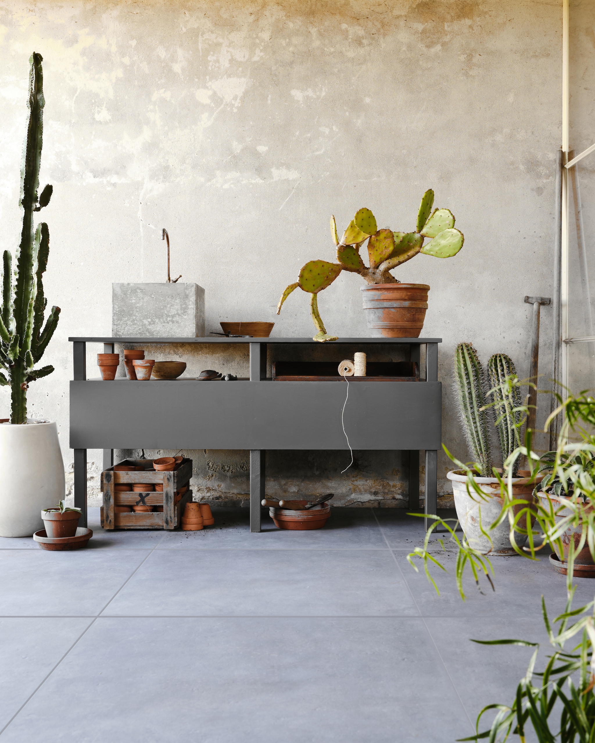 Tuintegel Solostone Mold Basalt van vtwonen, 70x70 cm € 79,95 per m² (ook in de kleuren Taupe en Grit).M.m.v. com-anders.nl (werkbank/buitenkeuken inclusief wasbak en kraan), intratuin.nl (terracotta bloempotten). Overig privébezit. vtwonen 03-2023 | productie Tanja Saarberg | styling Marlies Does | fotografie Bart Brussee