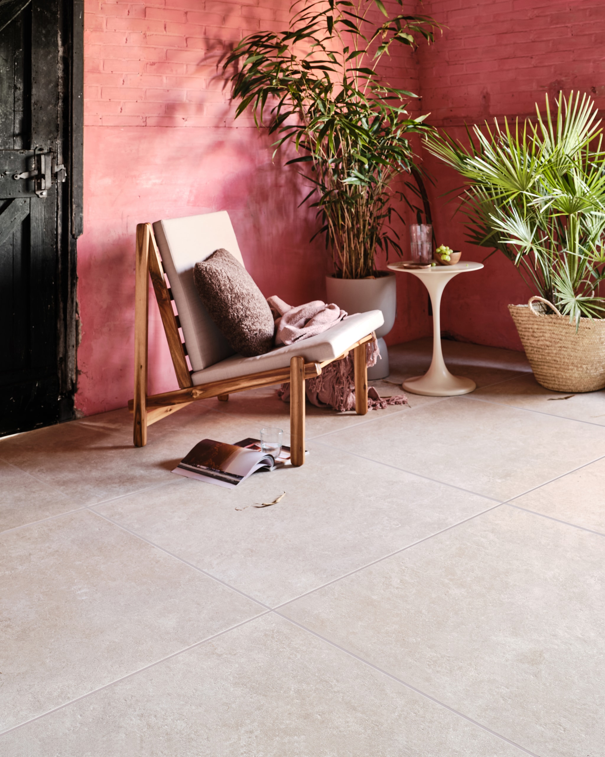 Tuintegel Solostone Unico Sand van vtwonen, 90x90 cm, per m² € 89,50. Ook in de kleur Antracite. vtwonen.nl (loungestoel Gani van Bloomingville, kussen vtwonen collectie, plaid van Malagoon, glas en karaf van Serax, bloempot van Elho), householdhardware.nl (bijzettafel, rieten mand), com-anders.nl (houten bakje en schotel). vtwonen 03-2023 | productie Tanja Saarberg | styling Marlies Does | fotografie Bart Brussee