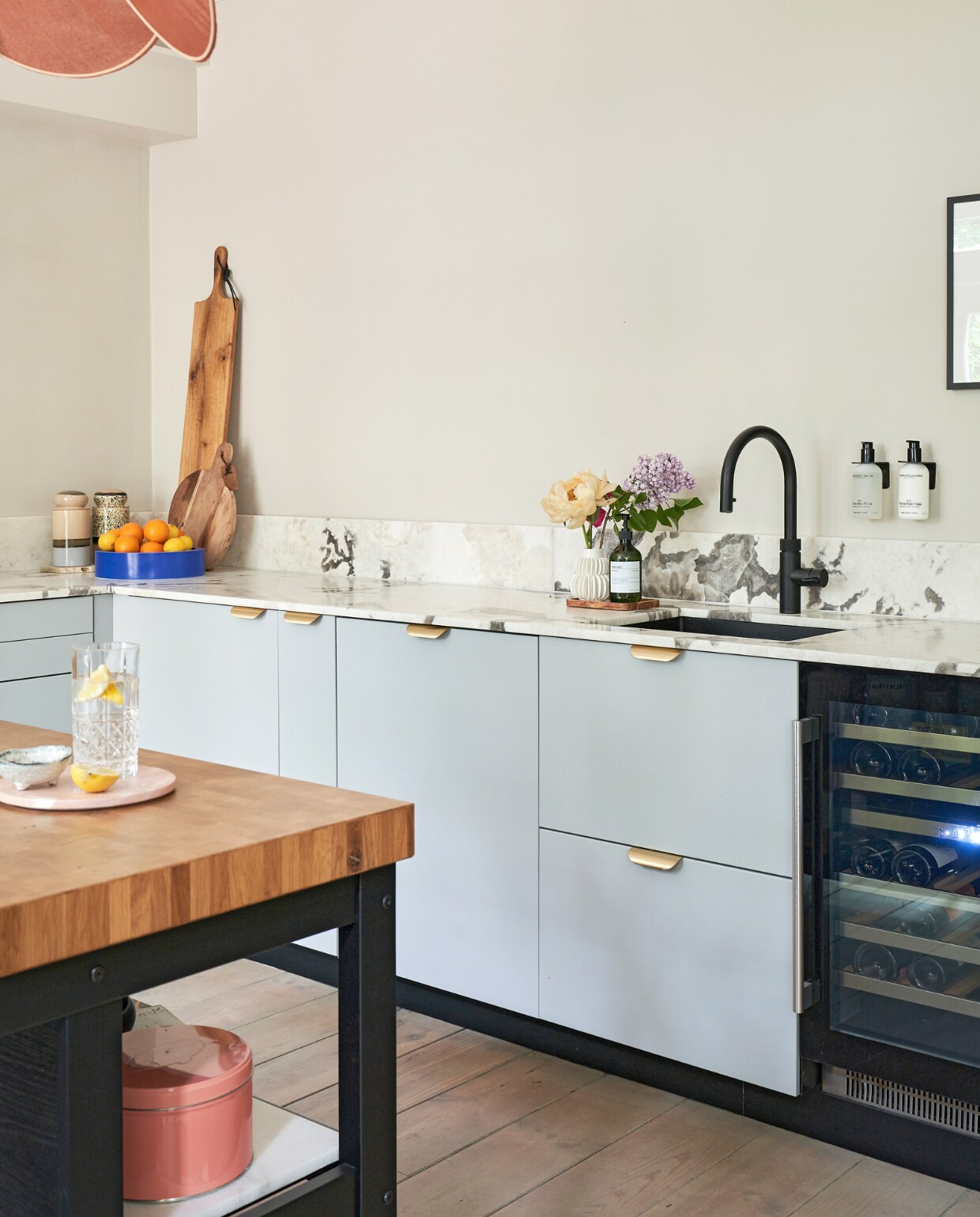 Muurverf Champignon van Gamma, keuken Veddinge en keukeneiland Ikea, marmeren blad Jan Reek Natuursteen. Messing grepen Luste, zeep en wandzeephouders Meraki. Blauwe fruitschaal Fést, suikerpotten HKliving, wit vaasje Fonq, kraan Quooker, wijnkoelkast Boretti. Hanglamp Georges Store, roze koekblik Het Koekemannetje, roze dienblad Monday is a state of mind, witte schaal met pootjes Broste Copenhagen, drinkglas Libbey. Originele houten vloer, houten planken onbekend. productie CocoFeatures | fotografie Muk van Lil | tekst Caroline Westdijk