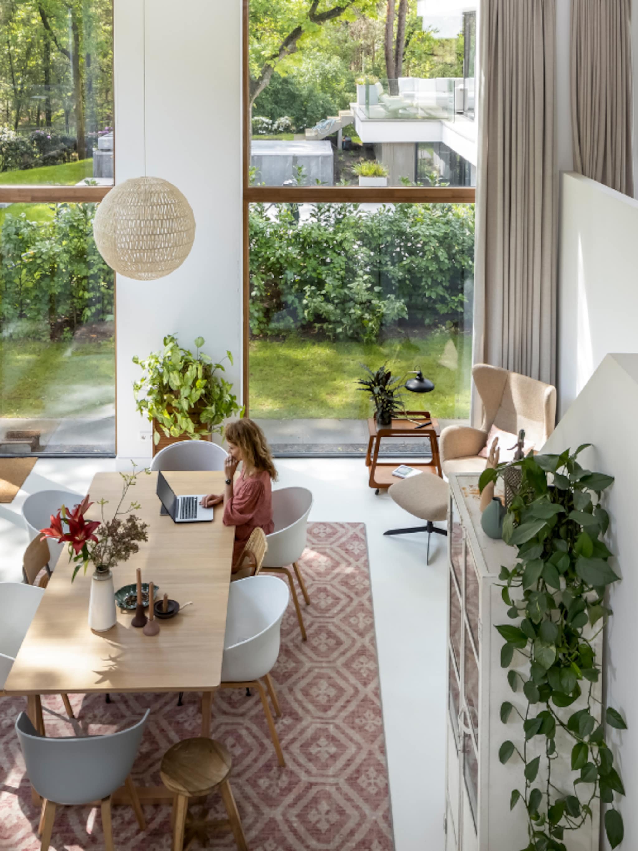 binnenkijken in een duurzaam gebouwde houten villa vanuit de woonkamer kijk ik zo het bos in