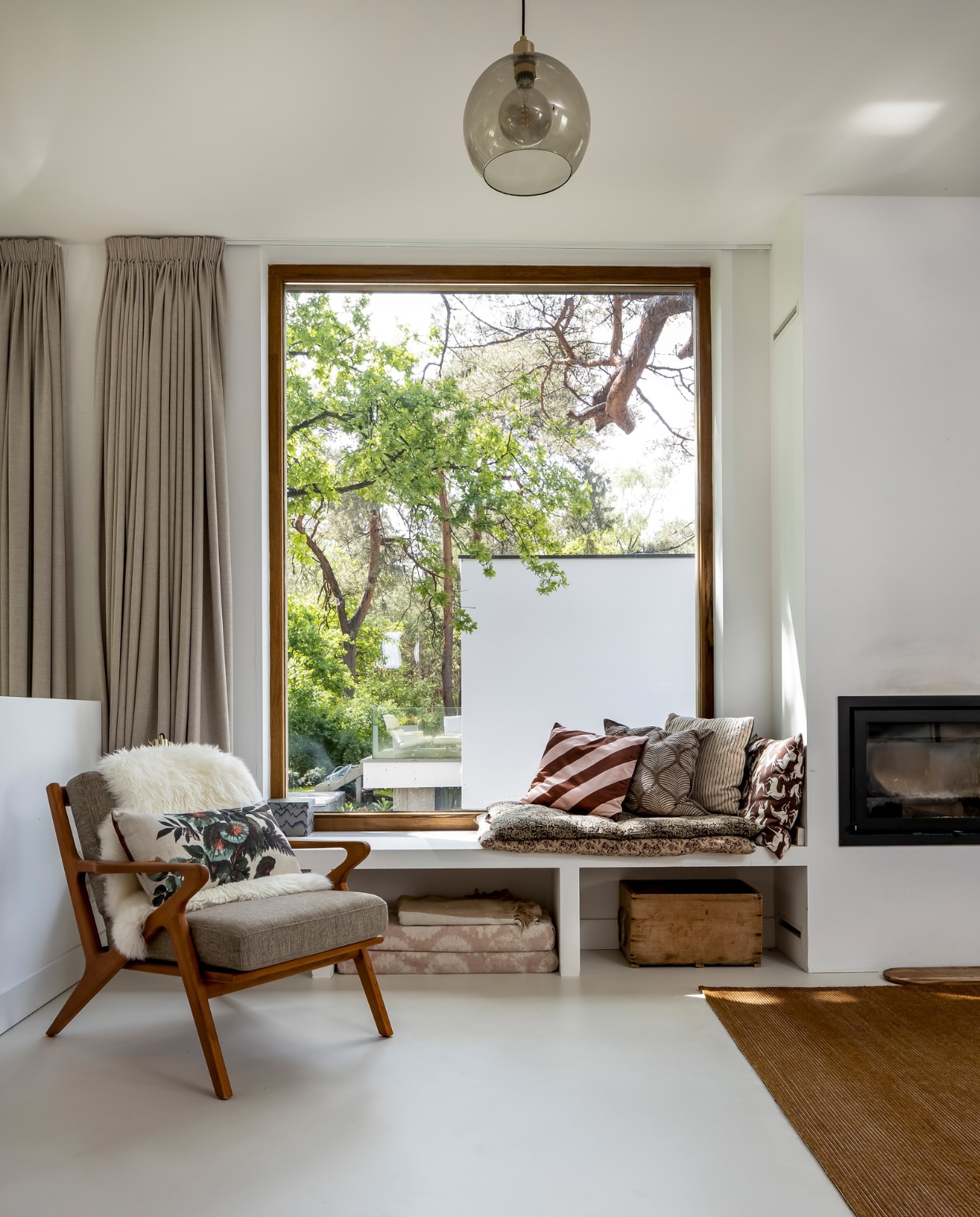 Kozijn van milieuvriendelijk geproduceerd Platowood. Stoel en rechterkussen op vensterbank Sissy-Boy, schapenvacht Ikea, kussen in stoel HKliving. Matraskussens onder bank zelfgemaakt van oude gordijnstof. Kussen links in vensterbank herkomst onbekend, tweede kussen House Doctor, derde Karwei. Matrassen Madam Stoltz, kist rommelmarkt, kleed Fonq. vtwonen 03-2023 | styling Martine Jeuken | fotografie Henny van Belkom | tekst Eveline Stoel