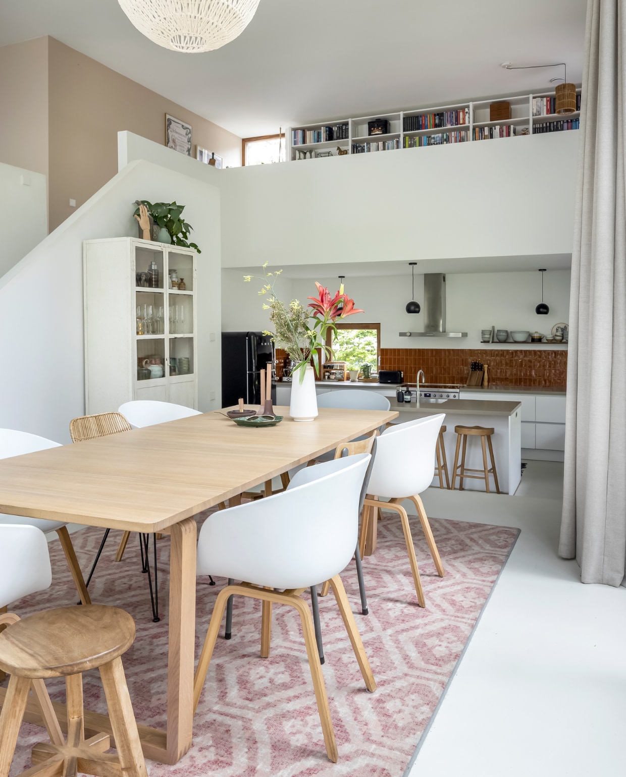 Eettafel Bolia, eetkamerstoelen Hay, vintage schoolstoelen, apothekerskast en kleed van Desso via Marktplaats, kruk Nijhof, vaas Hema, kandelaars cadeau gekregen, schaal herkomst onbekend, lamp Zuiver, houten schildershand Ikea, muurkleur Mild Umber van Flexa. vtwonen 03-2023 | styling Martine Jeuken | fotografie Henny van Belkom | tekst Eveline Stoel