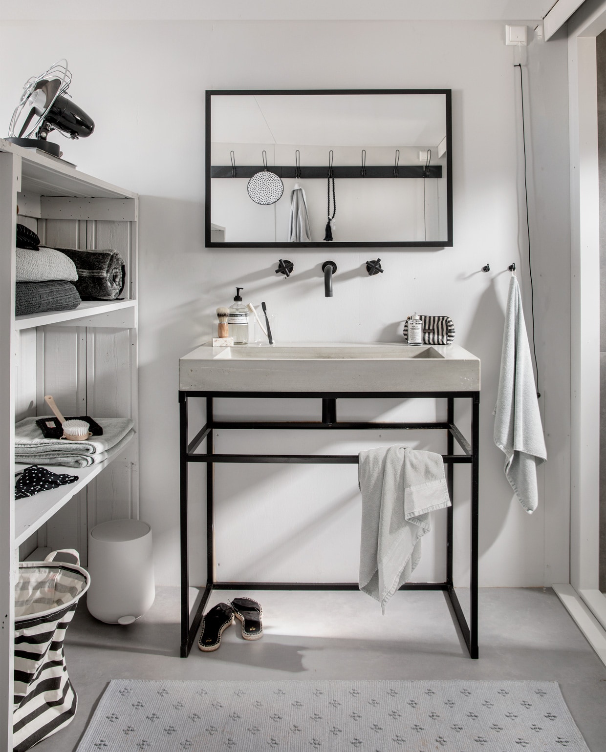 Vloer Novilon kleur IJzer, 200 of 400 cm breed, per m² € 27,25, wand geschilderd in kleur Light Grey, per liter vanaf € 18,95, spiegel Goodmorning black met lijst, 90x60 cm € 169,-, wasbak Tank Concrete, 90x46x10 cm (bxdxh) € 969,-, onderstel Floor Frame, 90x84x45 (bxhxd) € 455,-, kraan Cross € 479,-, handdoeken Stone wash Light Grey 100% katoen vanaf € 4,95. M.m.v.: loods5.nl (toilettas), overig privébezit. vtwonen 2019-07 | fotografie Peggy Janssen | styling Kim van Rossenberg, Danielle Verheul