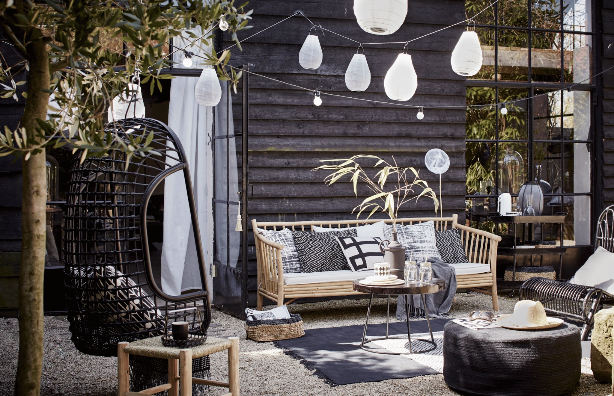 Bamboe bank van Tine K Home, 190 cm breed € 675,- (l’Etoile Conceptstore). Kussens op de bank van linksaf: hoes met vervaagde ruit, Worn van House Doctor, 50x50 cm € 17,95, zigzagkussen Graphy van Casa Vivante 60x40 cm € 29,95, wit kussen met zwart grafisch motief Lifestyle Manhattan 50x30 cm € 34,95 (www.vtwonen.nl). Plaid € 44,- (Hammam 34). Rotan hangstoel van HK Living € 199,95 (www.vtwonen.nl). Erin kussen Feathers van Littlephant, 50x50 cm € 65,95 (Livv Lifestyle). Plaid € 29,99 (H&amp;M). Marokkaanse gevlochten kruk van HK Living, groot 37x37x42 cm, klein 31x31x25 cm, samen € 65,-, salontafel Kraton van Dutch Bone, Ø 60 cm € 169,-; matzwarte vaas van Madam Stoltz € 44,95, juten poef van HK Living, 30x70 cm (hxØ) € 149,- (www.vtwonen.nl). Mason Jar drinkbekers set van 4 € 9,95 (vtwonen.nl). Houten bordjes € 6,95 van HK Living, emaillen zwart-wit potje set van 2 € 9,95 (www.vtwonen.nl). Rieten hoed € 39,95 (Sukha Amsterdam). Vloerkleed Stack van House Doctor € 164,95; zwarte rotan stoel van House Doctor € 245,- (www.vtwonen.nl). Zwart-wit vloerkleed € 29,99 (H&amp;M). Lampions Drop van House Doctor, 30x20 cm (hxØ) per 2 € 9,95 en 35x24 cm (hxØ) per 2 € 12,95, lichtsnoer Bella Vista van Seletti, 10 lampen, 14,2 meter € 99,- (www.vtwonen.nl). Visnet € 3,95 (Sissy-Boy Homeland). Gordijn set van 2 € 9,95 (Ikea). Rieten lage manden van Serax set van 3 € 79, (www.vtwonen.nl). vtwonen 2015-06 | fotografie Alexander van Berge | styling Cleo Scheulderman