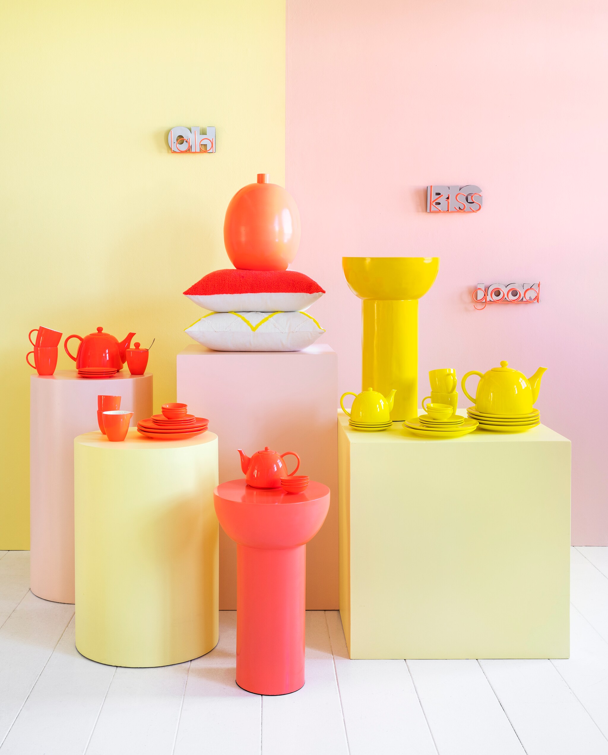 Neon Collectie 2023/03. Spiegels Fluo v.l.n.r.: Oh La La, 17,5x9,5 cm € 19,95, Big Kiss, 17,5x9,5 cm € 19,95,  Looking Good 17,5x9,5 cm € 19,95. Op roze vierkante pilaar: oranje metalen vaas Fluo,  26,5x34,5 cm (Øxh) € 59,95, ook verkrijgbaar in geel, katoenen kussen Fluo met oranje halve maan, 45x45 cm € 44,95, katoenen kussen met gele lijnen, 45x45 cm € 44,95. Op ronde roze pilaar: oranje mokken Fluo met oor 250 ml, set van 2 € 19,95 (ook in 400 ml € 24,95), oranje theepot Fluo 1800 ml € 44,95, oranje suikerpot Fluo 150 ml € 24,95, oranje schotels Fluo, 12 cm (Ø), set van 4 € 29,95. Op ronde gele pilaar: oranje mokken Fluo met oor 250 ml, set van 2 € 19,95 (ook in 400 ml € 24,95), oranje melkkan Fluo klein 150 ml (in set met suikerpot 150 ml) € 24,95, oranje theetip/sauskom Fluo, 7 cm (Ø), set van 4 € 16,95, oranje borden Fluo, 12 cm (Ø), set van 4 € 29,95. Oranje metalen bijzettafel, 31x50 cm (Øxh) € 99,95 met daarop: oranje theepot Fluo 1800 ml € 44,95, oranje theetip/sauskom Fluo, 7 cm (Ø), set van 4 € 16,95. Op gele vierkante pilaar: gele metalen bijzettafel, 31x50 cm (Øxh) € 99,95, gele theepot Fluo 1500 ml (alleen verkrijgbaar in set met 2 mokken zonder oor 150 ml) € 44,95, gele borden Fluo, 12 cm (Ø), set van 4 € 29,95, gele mokken Fluo met oor 250 ml, set van 2 € 19,95, gele theetips/sauskommen Fluo, 7 cm (Ø), set van 4 € 16,95, gele borden Fluo, 12 cm (Ø), set van 4 € 29,95, gele borden Fluo, 20 cm (Ø), set van 2 € 34,95, gele theepot Fluo 1800 ml € 44,95. vtwonen 03-2023 | productie &amp; styling Tanja Saarberg | fotografie Stan Koolen | assistentie Suzanne Fennema, Isa Hoevens